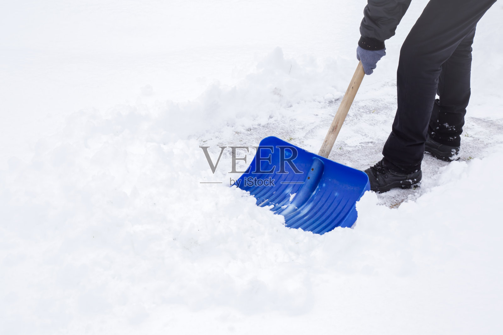 人们在冬天用铁锹清扫积雪。照片摄影图片
