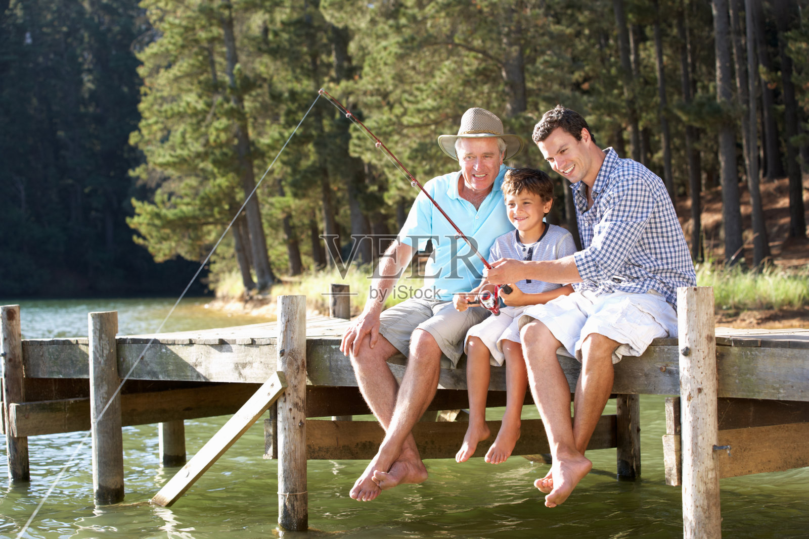 父亲，儿子和孙子一起钓鱼照片摄影图片