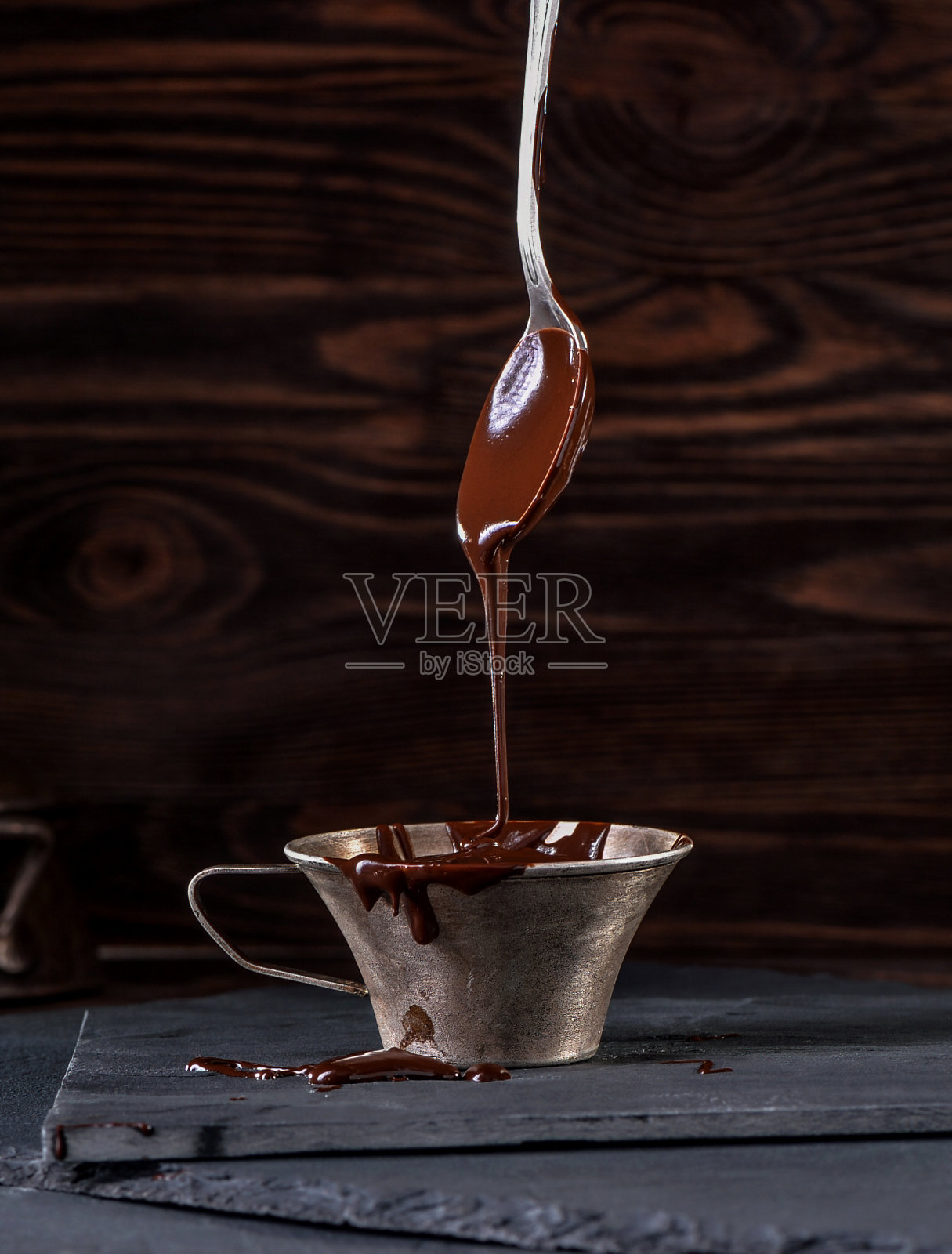 液态巧克力从勺子滴到杯子里照片摄影图片