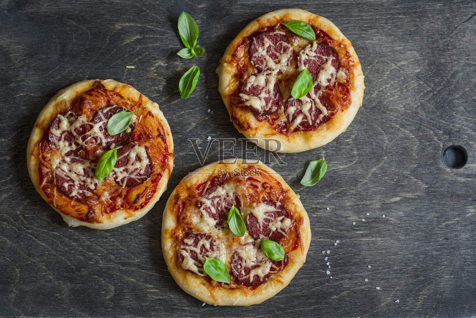 深色木质背景上的迷你腊肠披萨，俯视图照片摄影图片