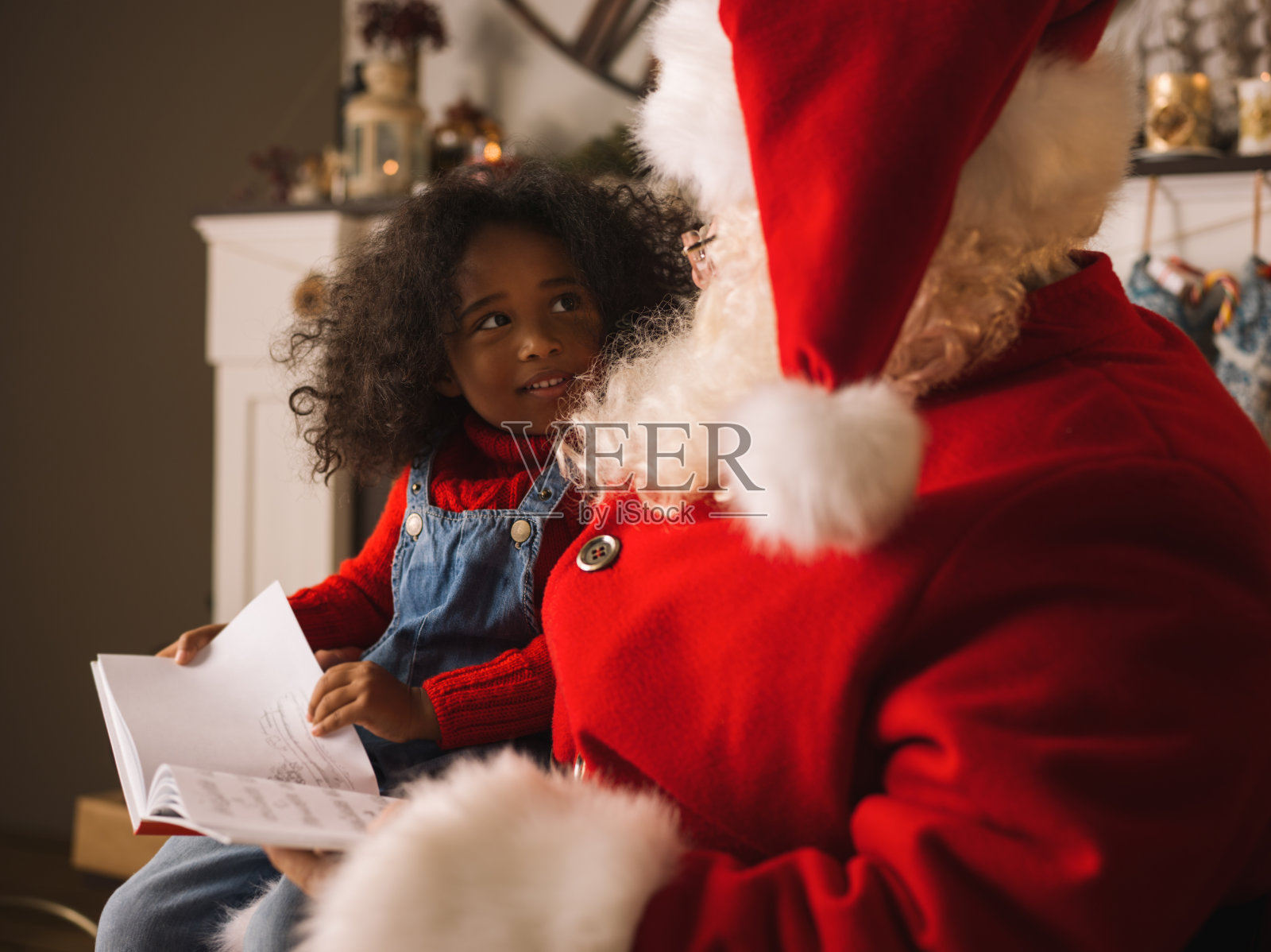 圣诞老人和孩子在圣诞树旁看书照片摄影图片