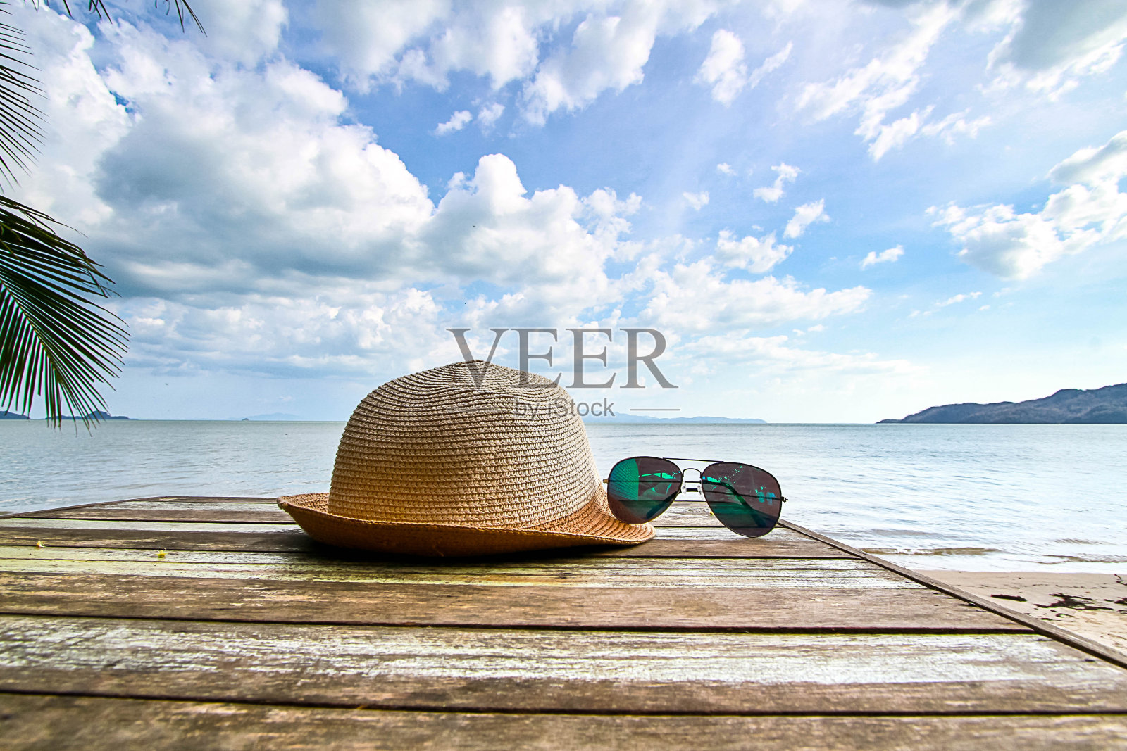 沙滩桌上放着草帽和太阳镜照片摄影图片