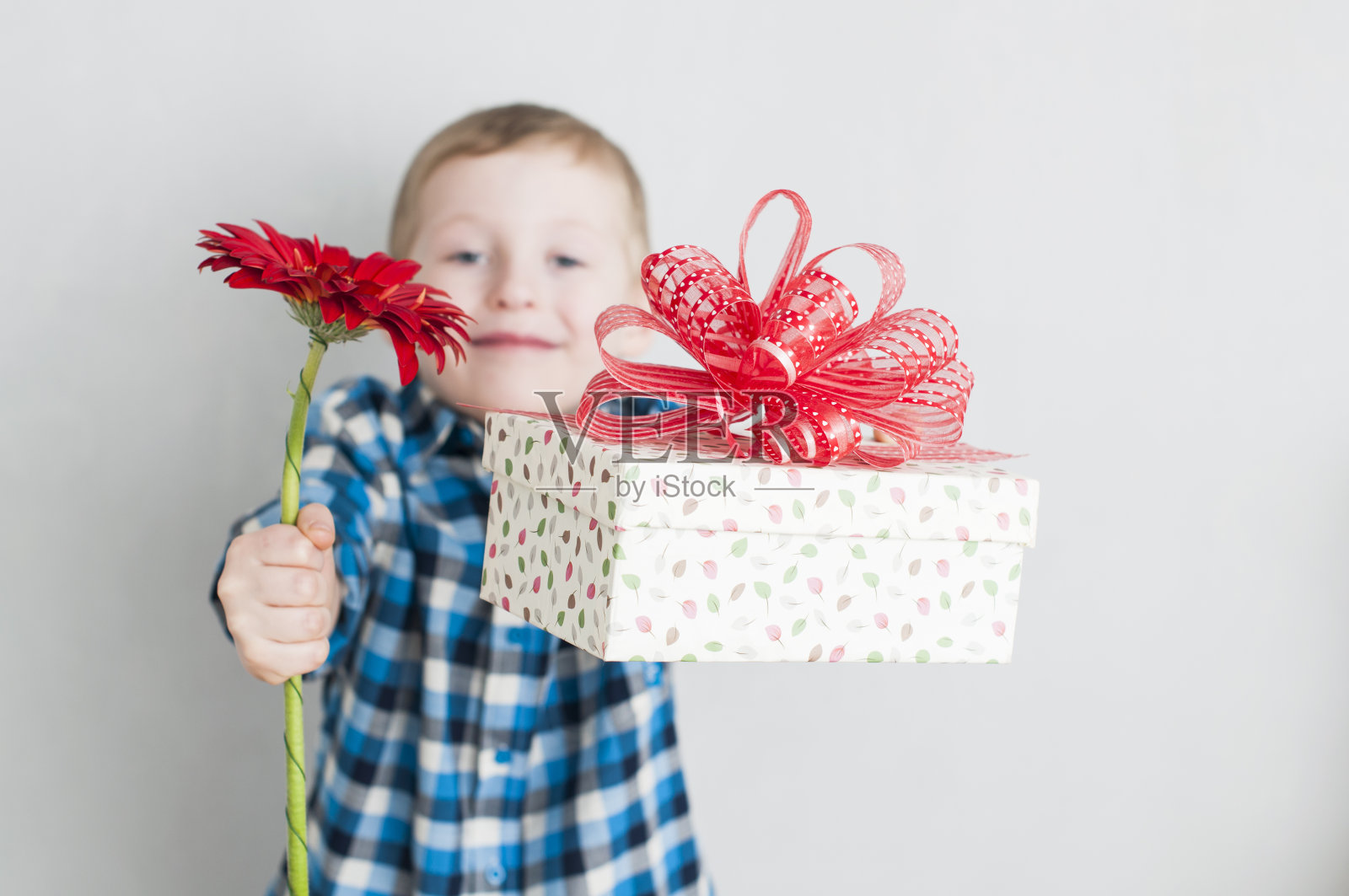 小男孩拿着红花和礼盒照片摄影图片