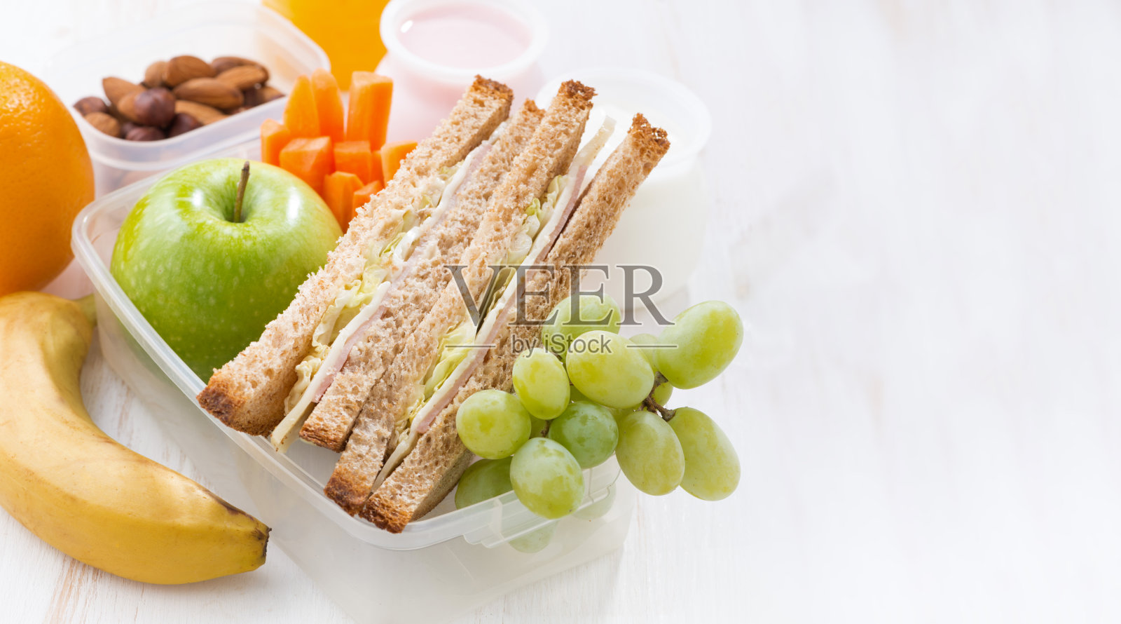 白色背景上有三明治和水果的学校午餐照片摄影图片