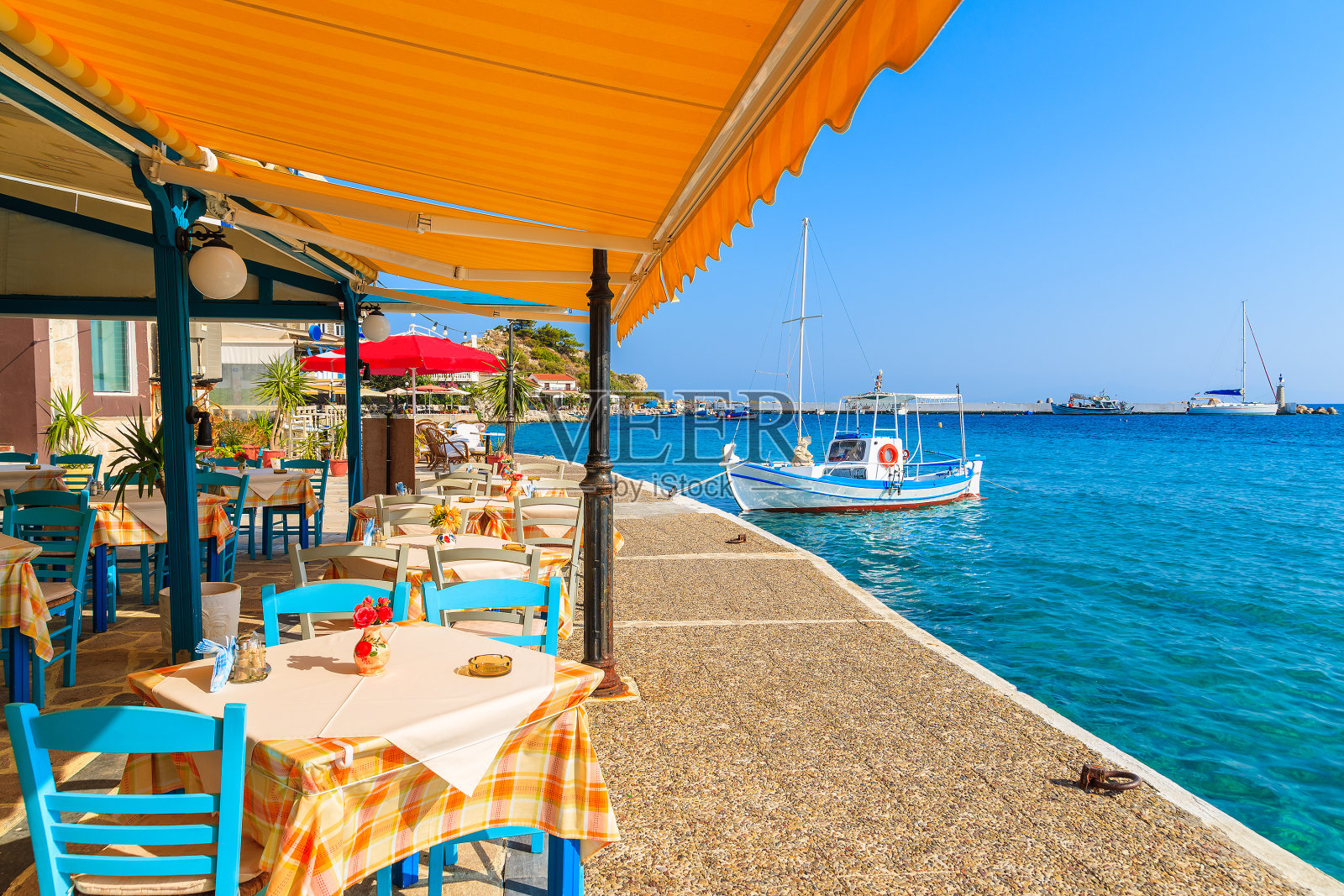 希腊萨摩斯岛海岸Kokkari镇的传统希腊酒馆里的桌子和椅子照片摄影图片
