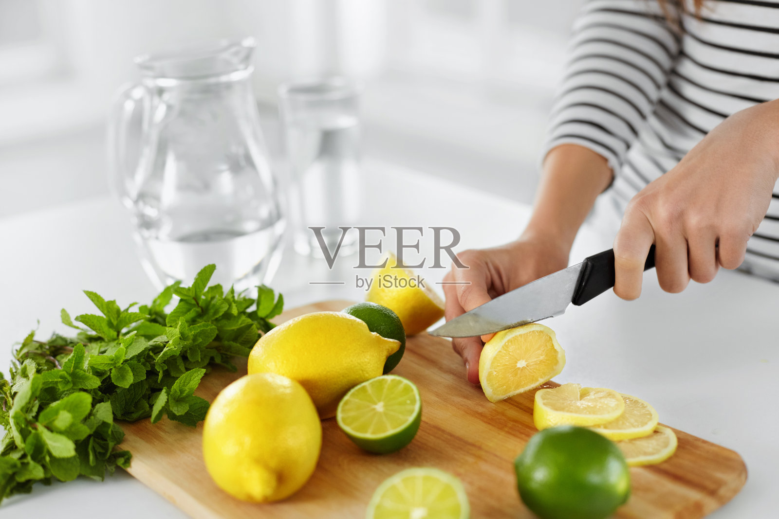 健康的食物和饮食。女人在厨房切柠檬的特写照片摄影图片