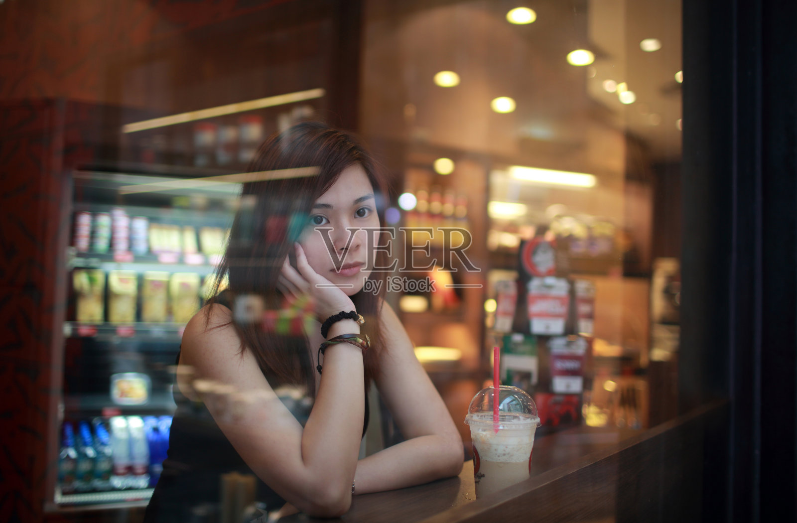 一个小女孩正从咖啡馆的窗户往外看照片摄影图片