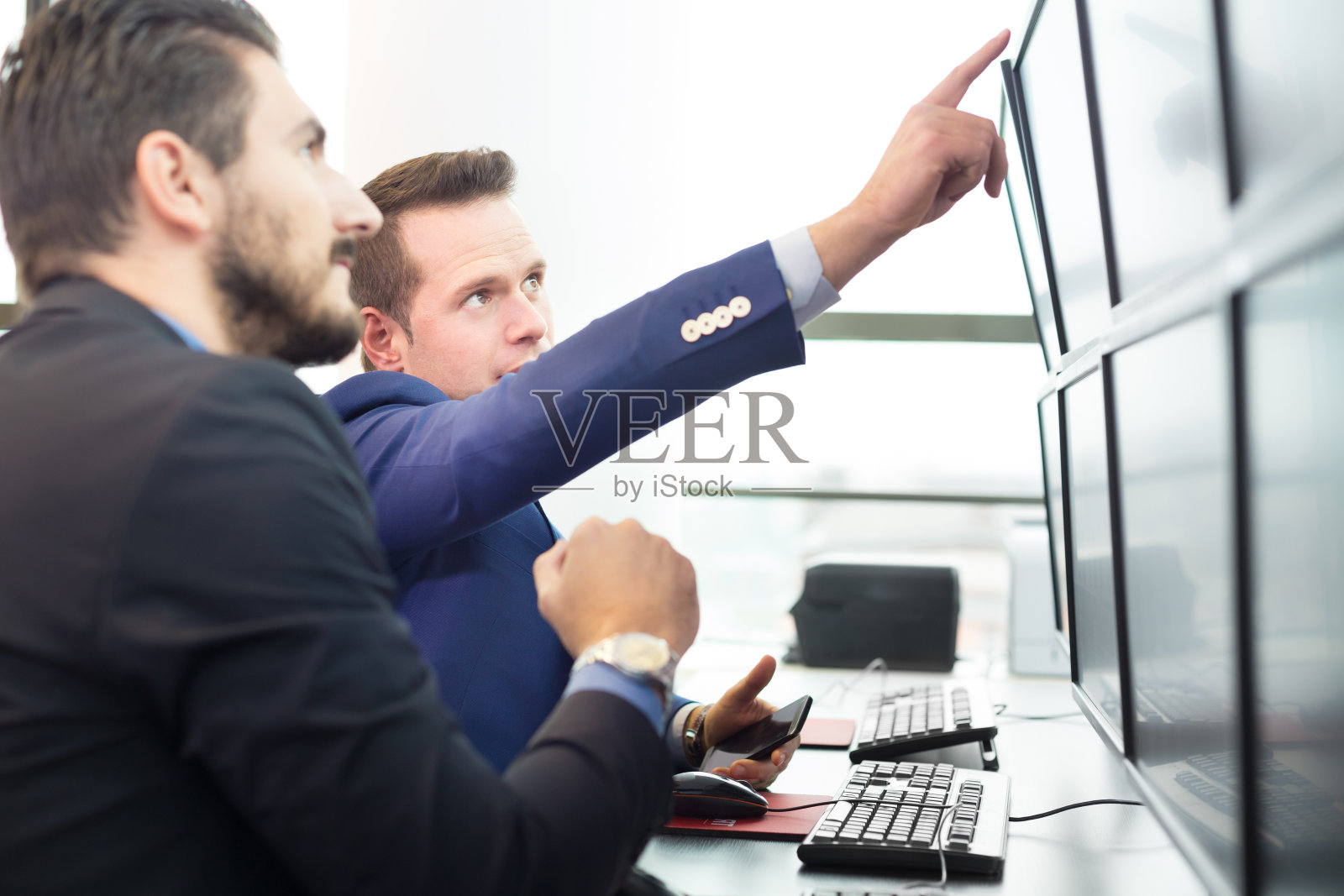 股票交易员看着电脑屏幕。照片摄影图片