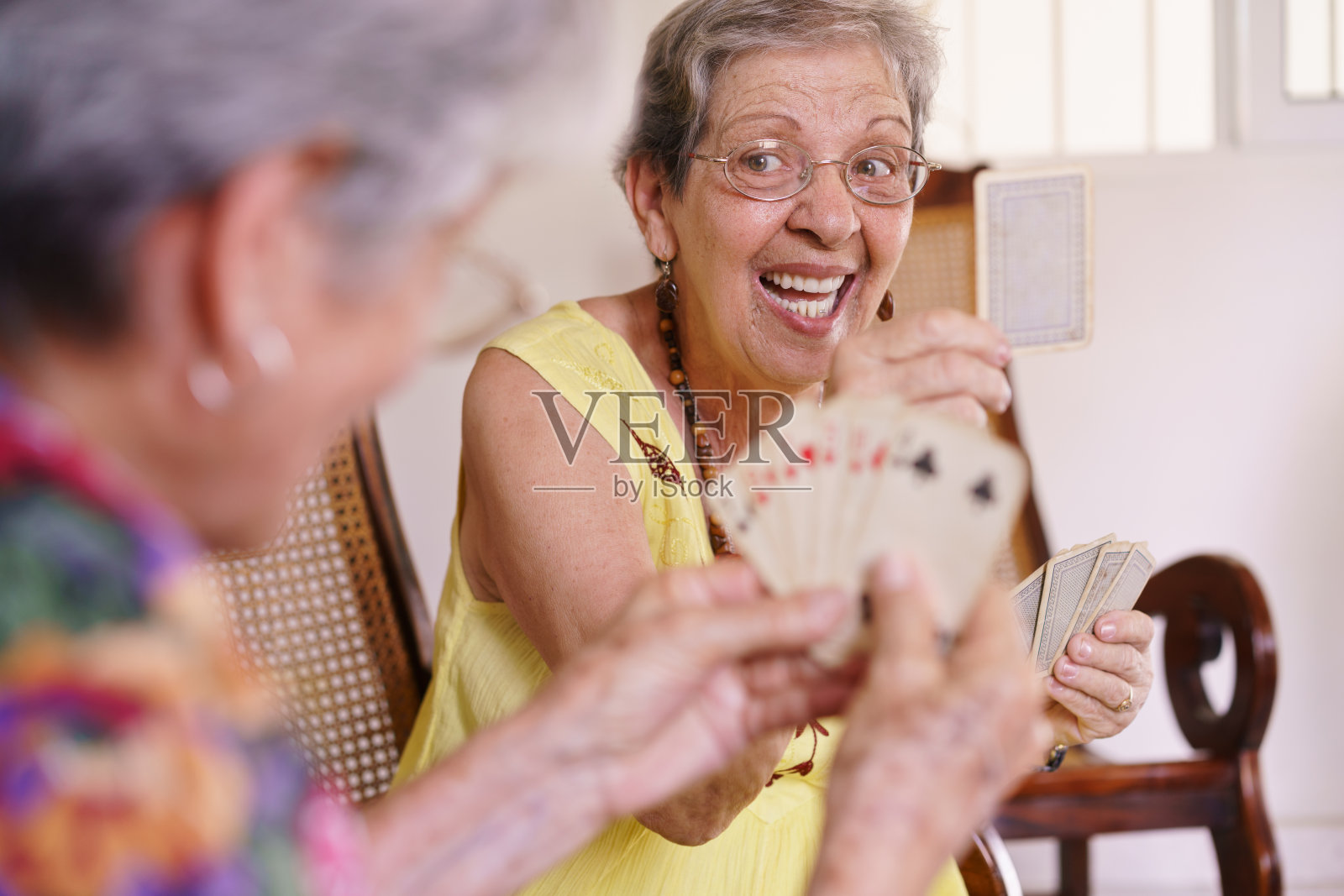 在临终关怀医院里，老年妇女喜欢玩纸牌游戏照片摄影图片