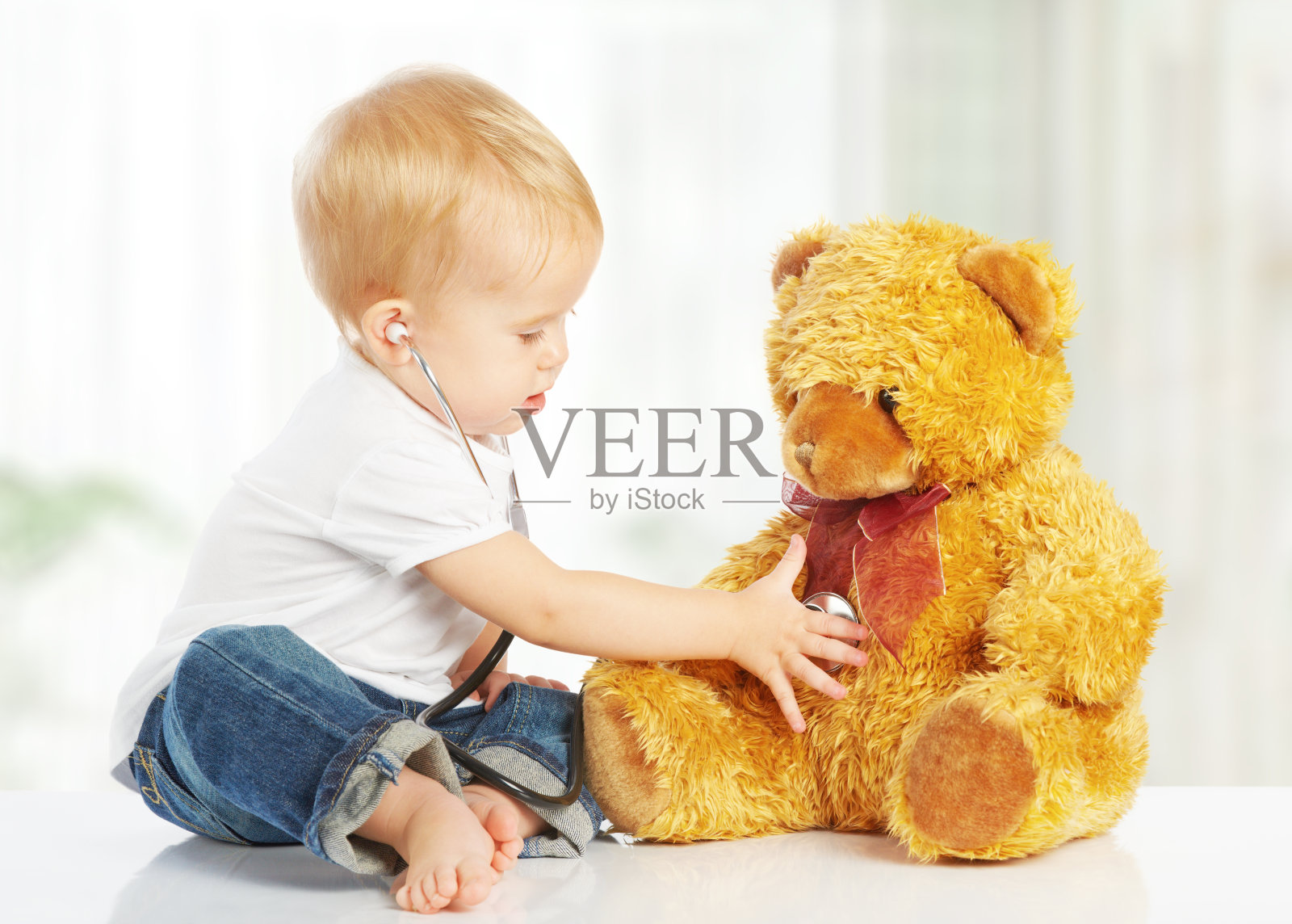 婴儿玩医生玩具，泰迪熊和听诊器照片摄影图片