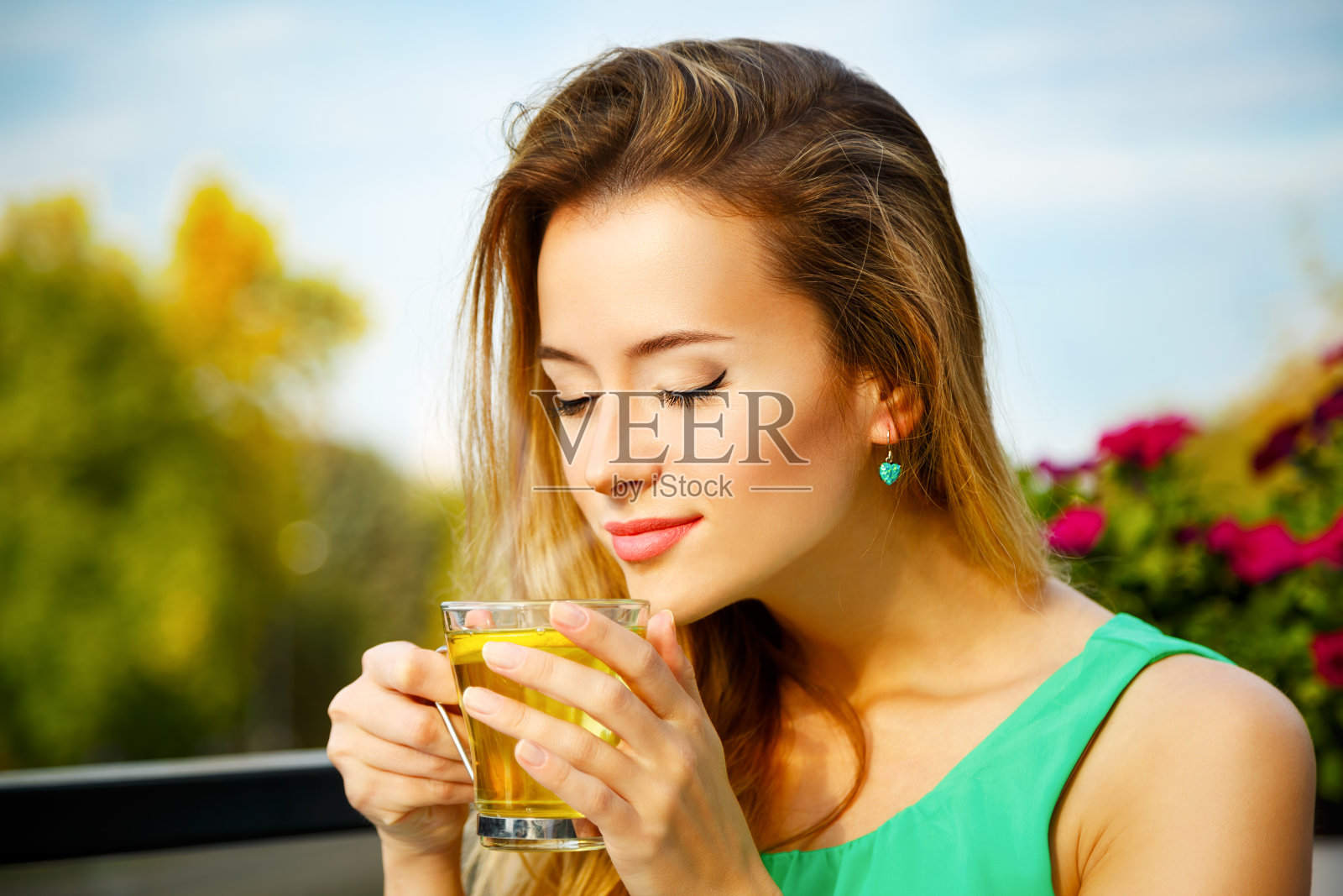 年轻女子在户外喝绿茶照片摄影图片