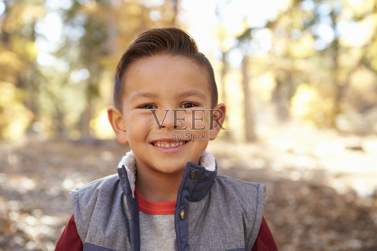 一个西班牙男孩在森林里的头和肩膀肖像照片摄影图片