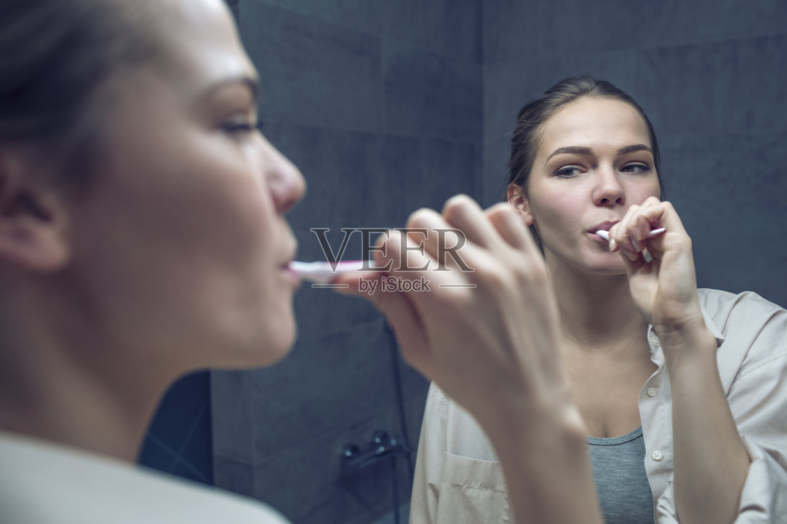 在浴室镜子前刷牙的女人照片摄影图片