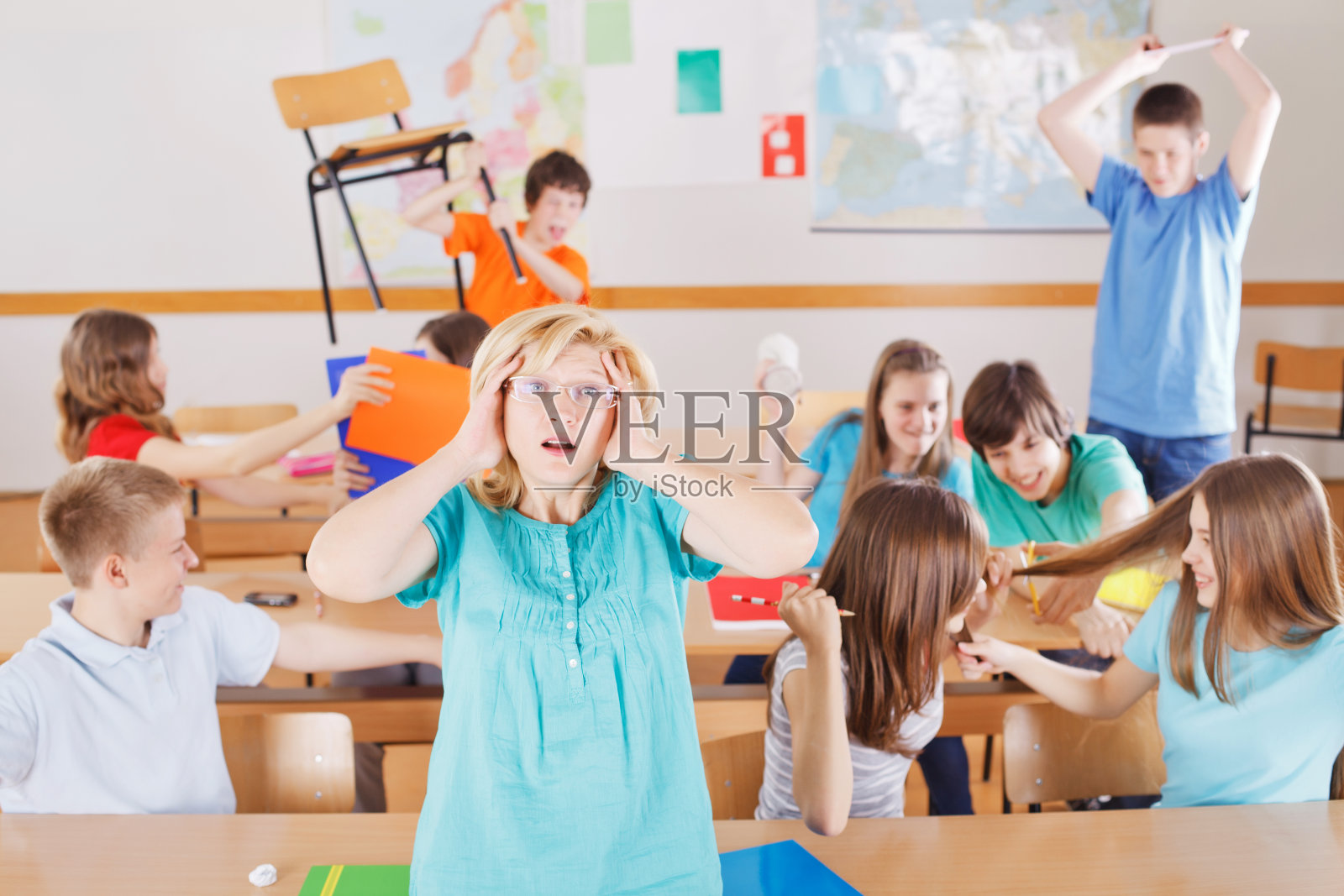 老师在课堂上很沮丧，她背后的学生表现不好。照片摄影图片