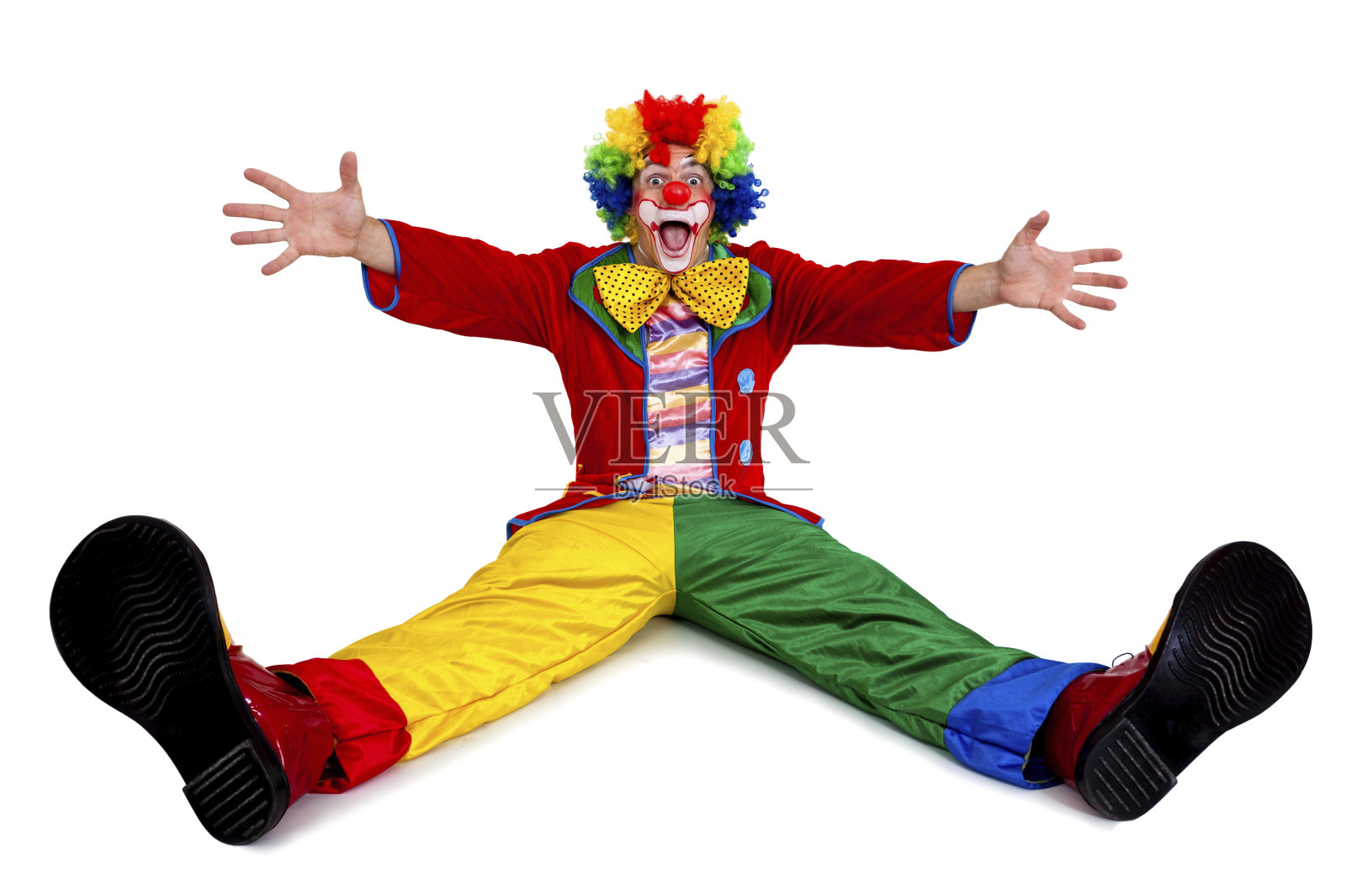 滑稽的小丑坐着伸开胳膊和腿照片摄影图片