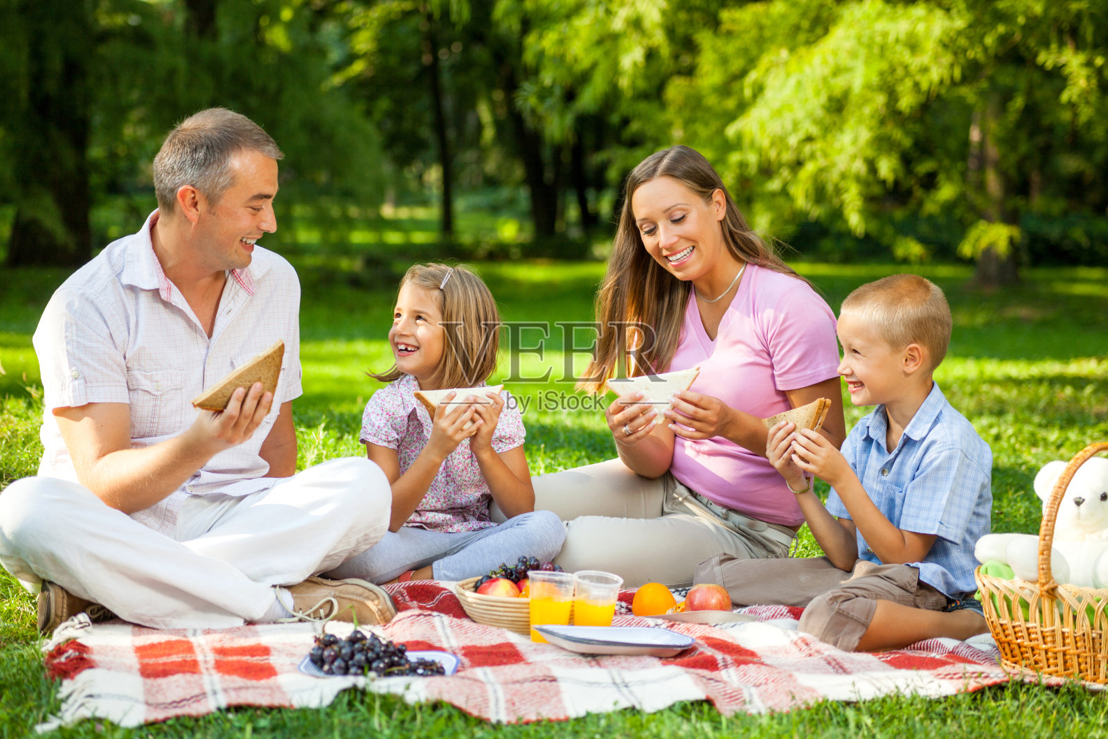 快乐的家庭在公园野餐。照片摄影图片