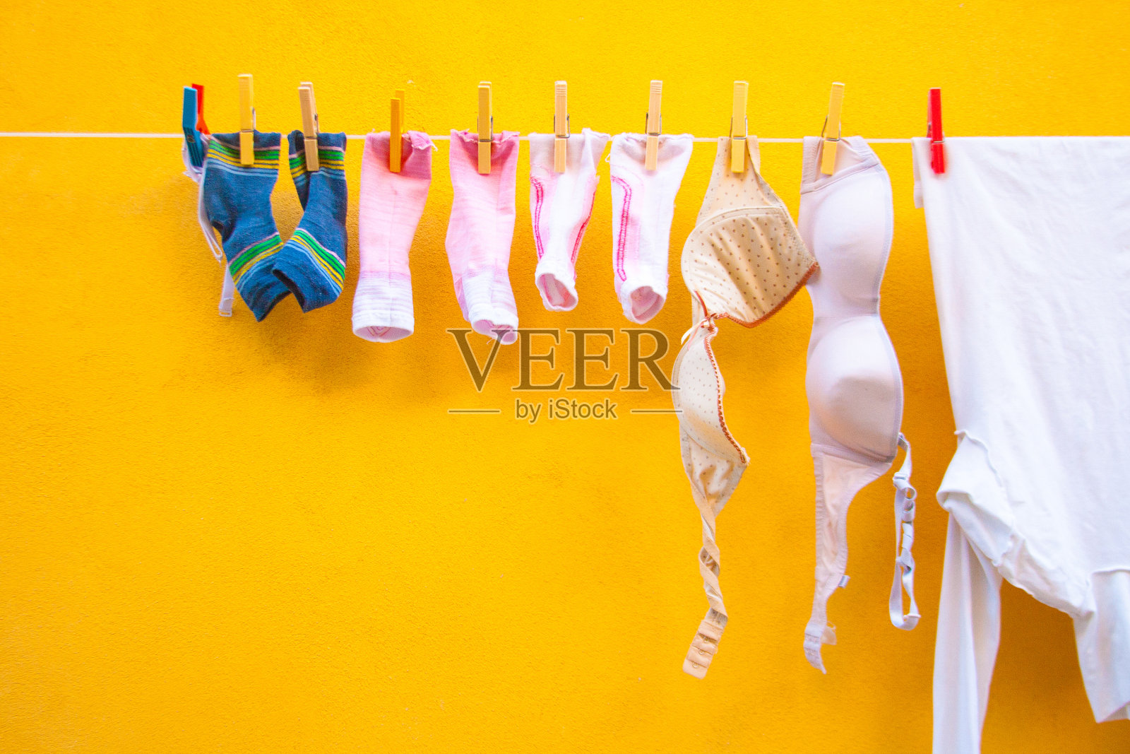 在线洗衣(袜子、胸罩、衬衫);充满活力的黄墙，意大利照片摄影图片
