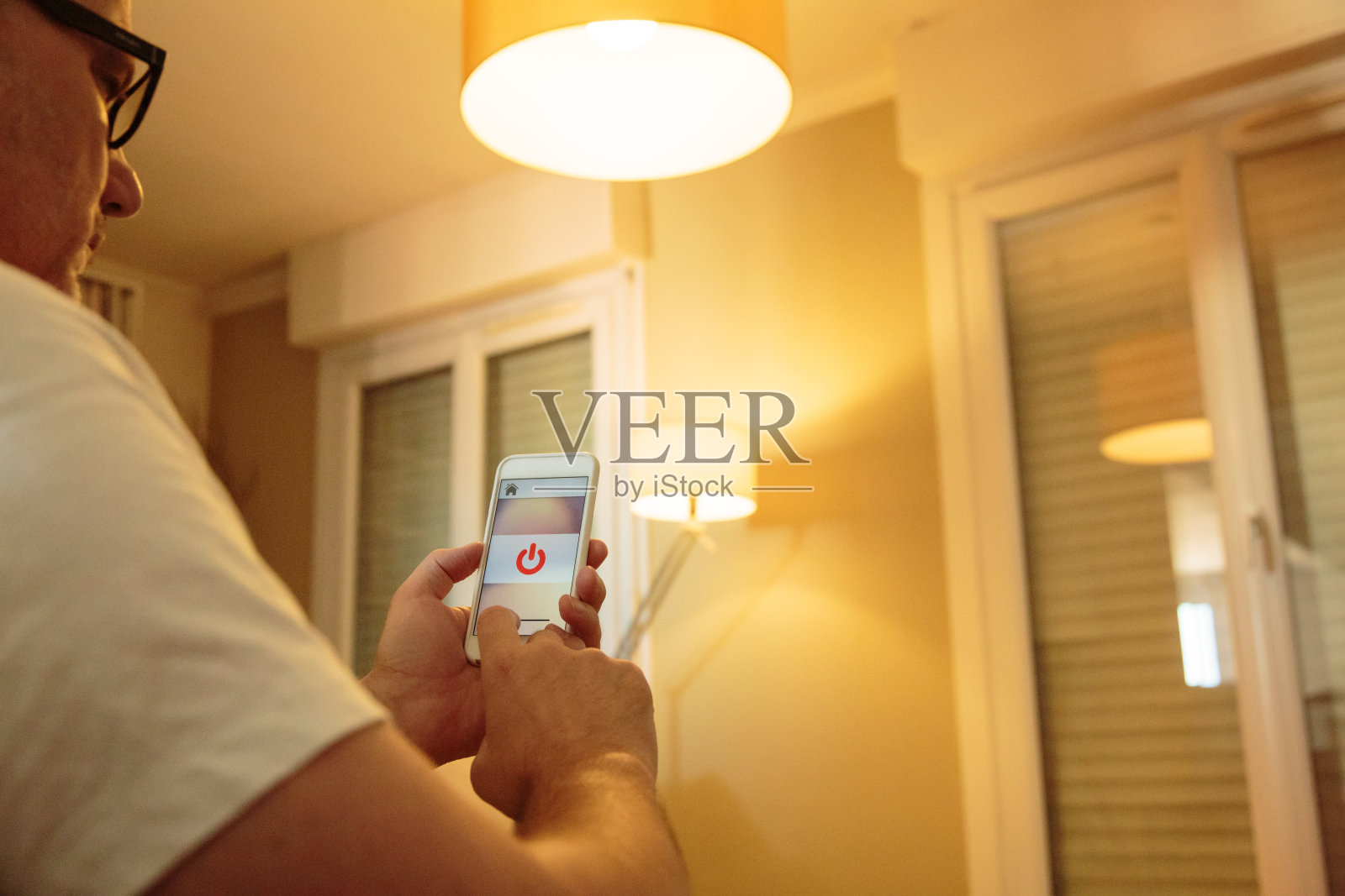 智能家居:男人用手机上的应用程序控制灯光照片摄影图片