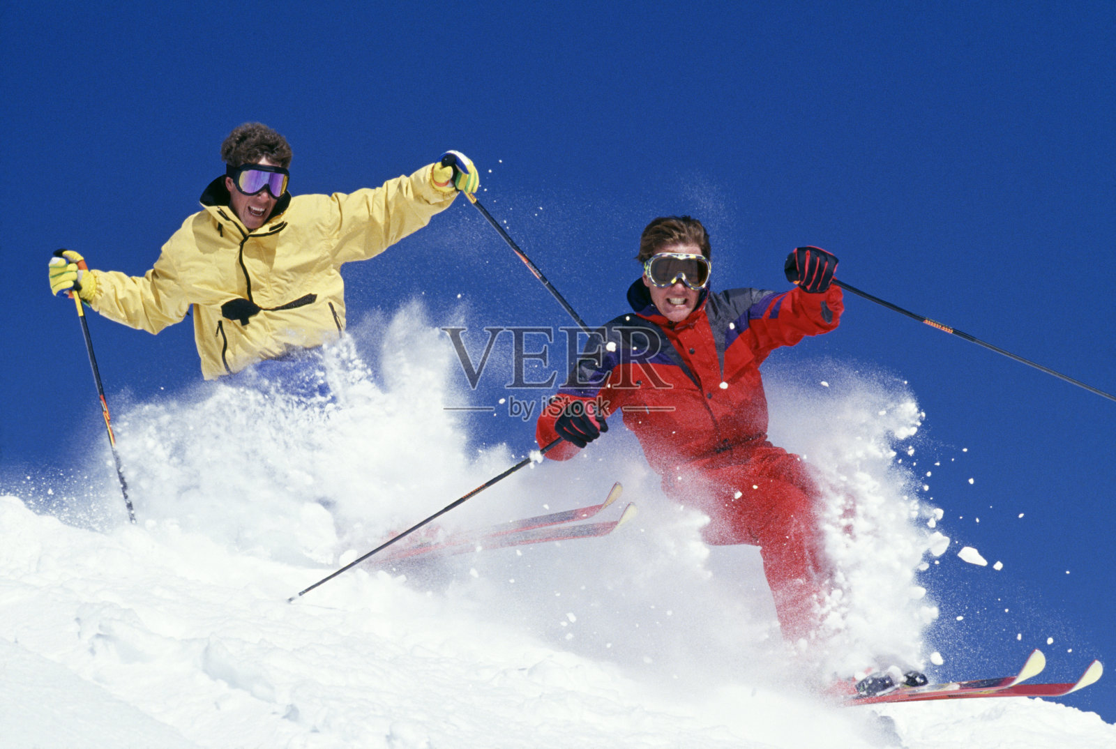 两名滑雪者在新鲜的雪粉中疾驰照片摄影图片