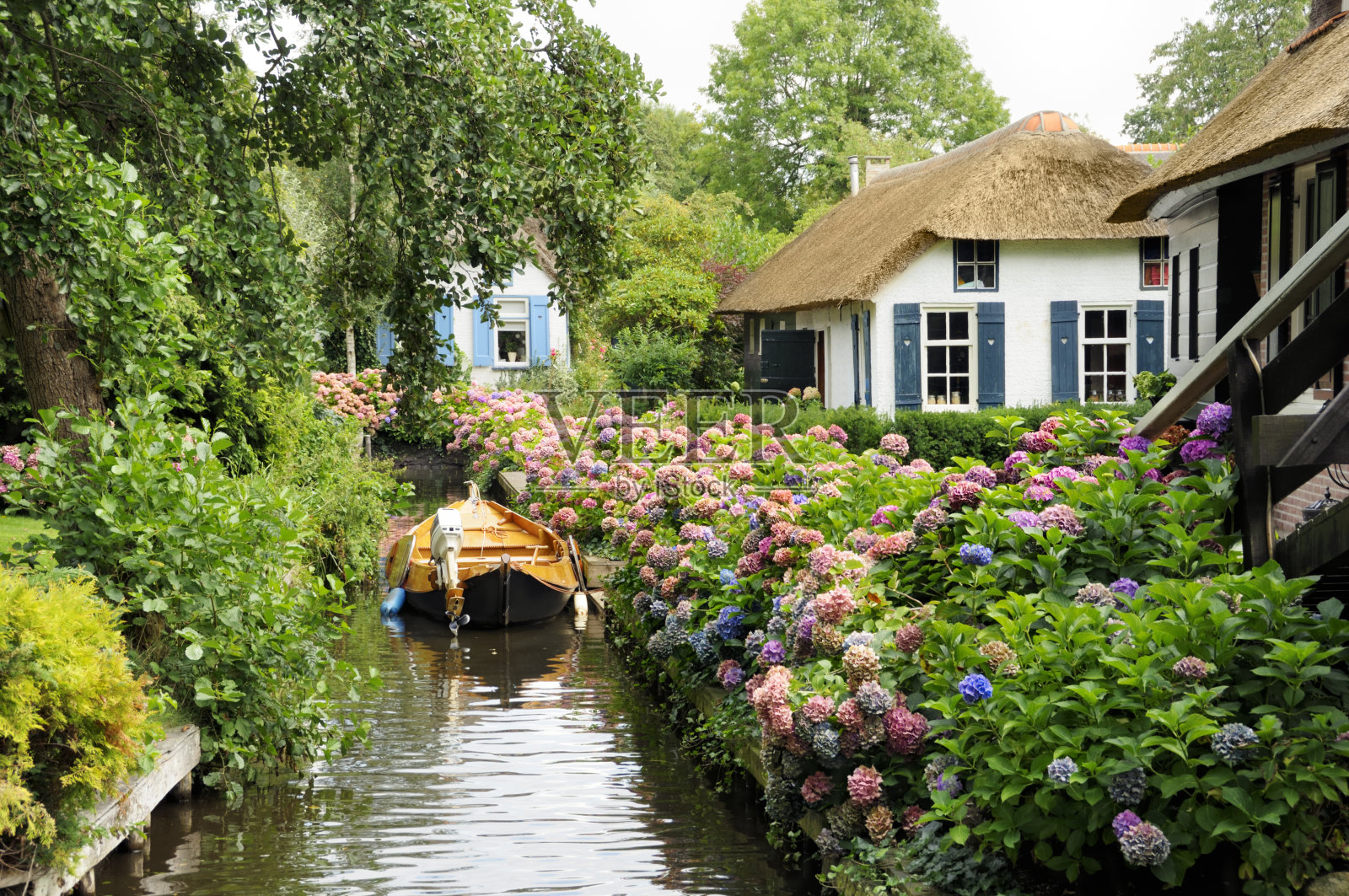 历史悠久的荷兰房屋有河、船和许多花照片摄影图片