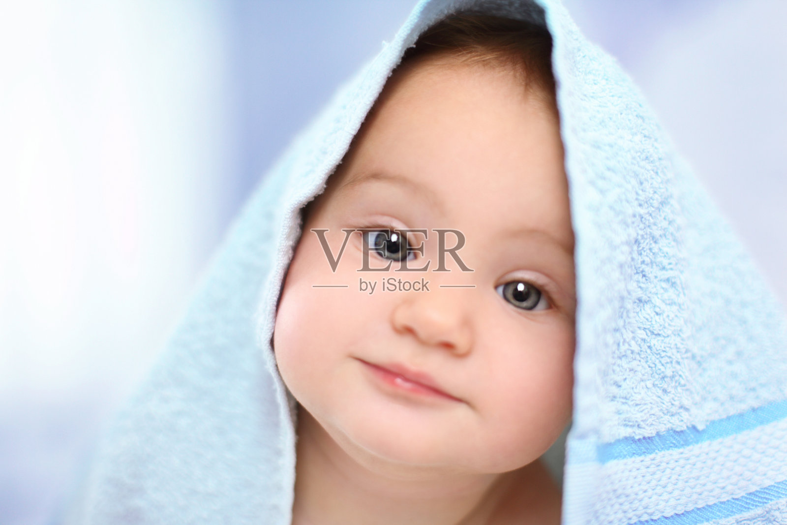 可爱的宝宝盖着毛巾。照片摄影图片