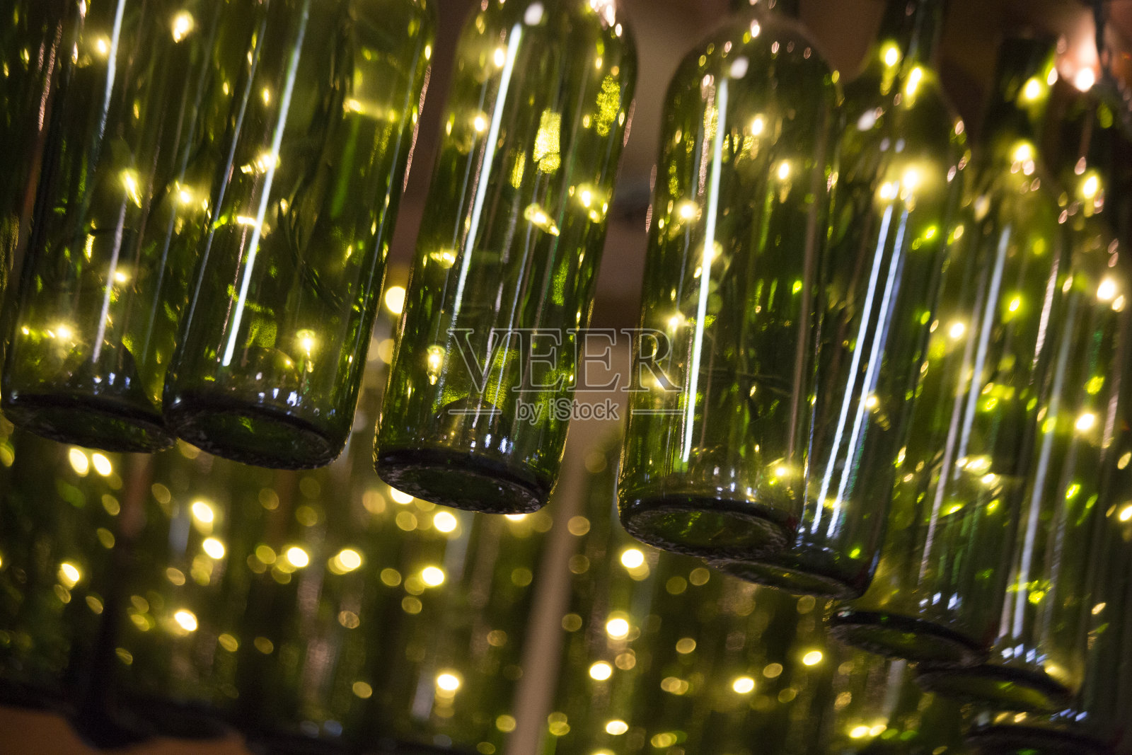 绿色酒瓶作为灯具，抽象背景照片摄影图片