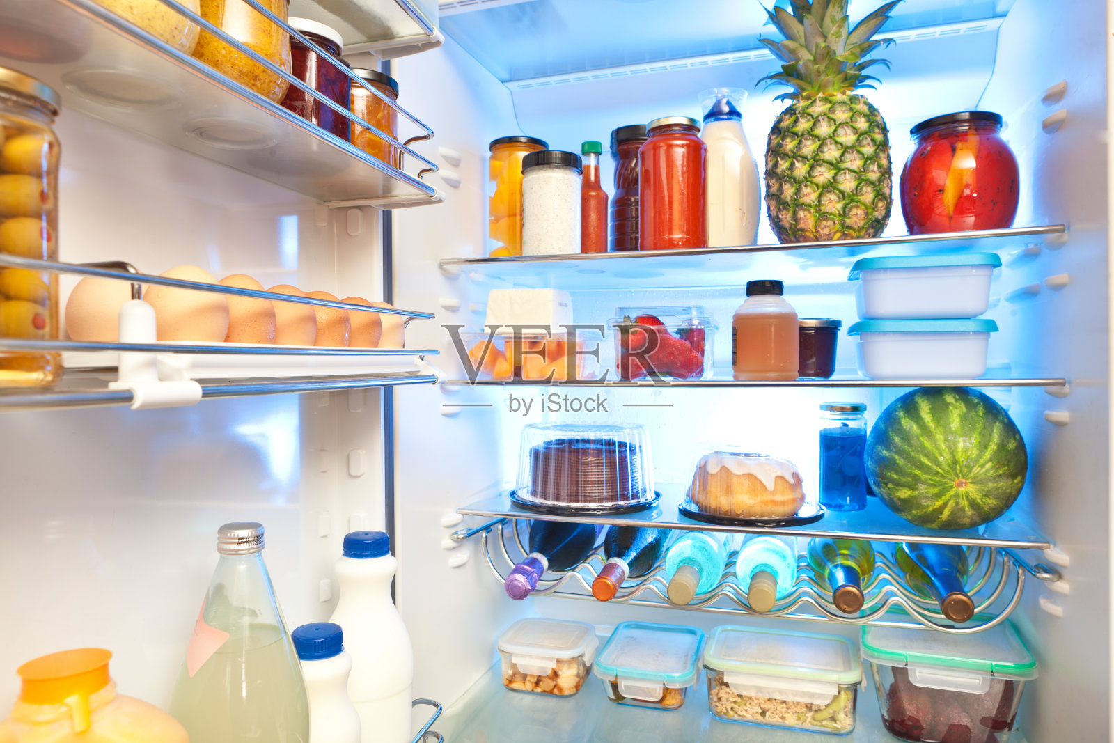 打开冰箱，把健康的食物放在里面照片摄影图片