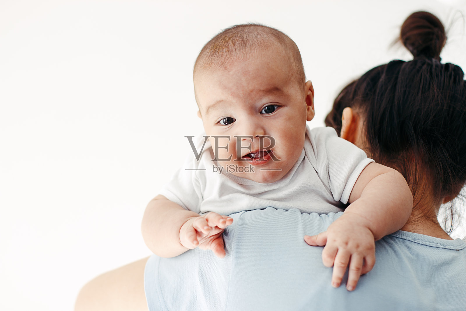 母亲给男婴喂奶后打嗝照片摄影图片