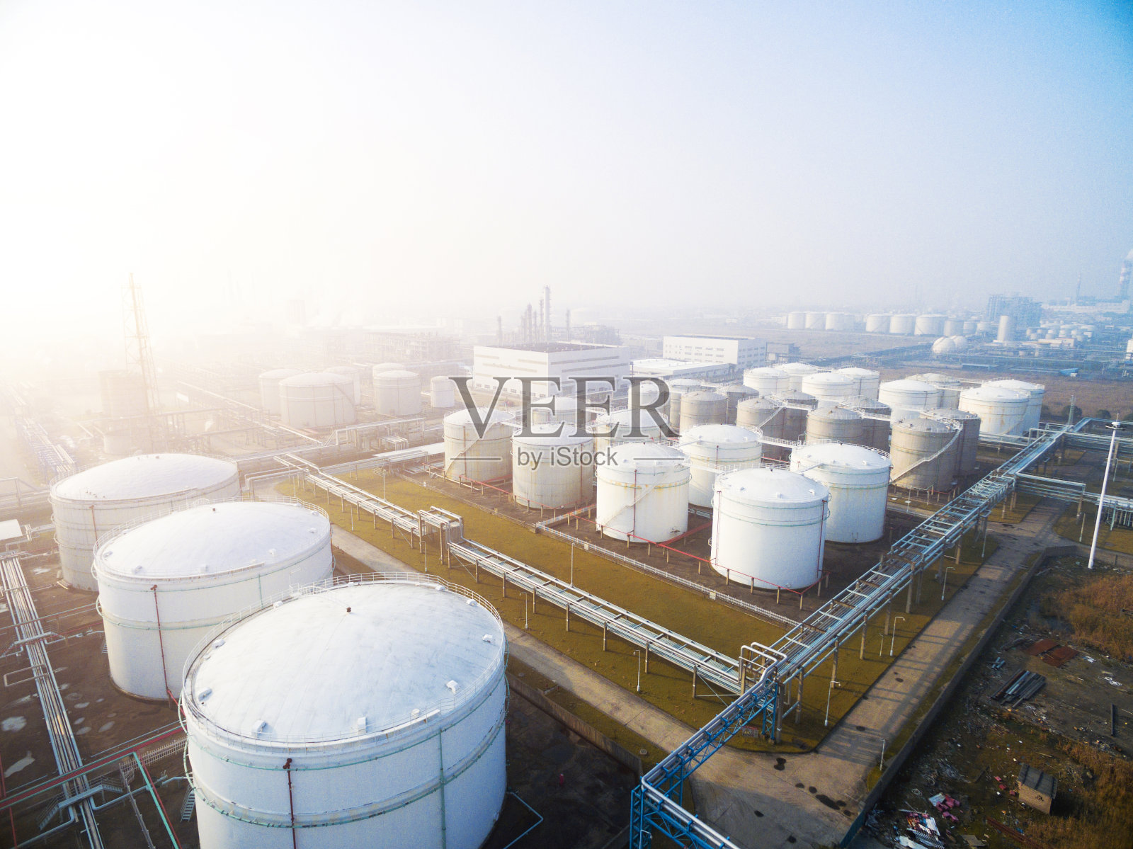 油罐在现代炼油厂的蓝天下照片摄影图片