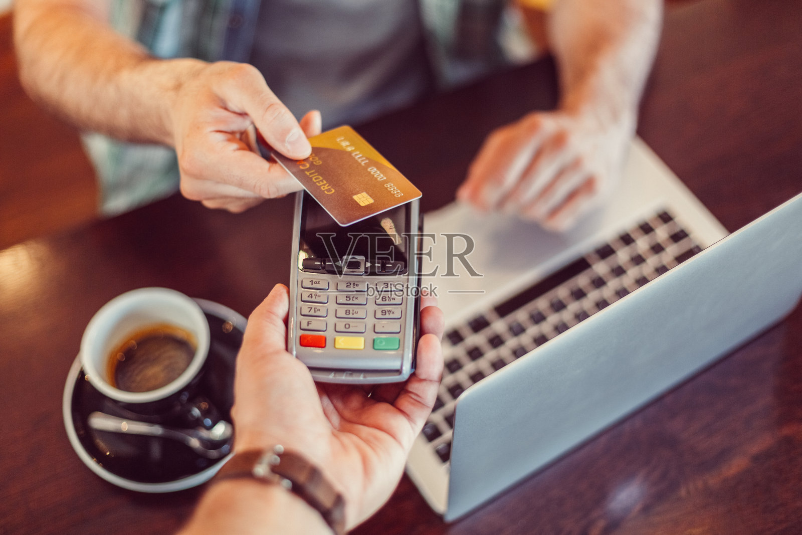 一名男子在咖啡馆进行非接触式信用卡支付照片摄影图片
