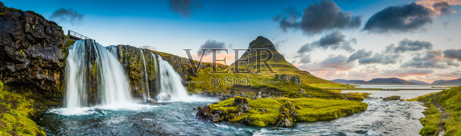 岩石山峰下的瀑布在日出的冰岛Kirkjufell全景照片摄影图片