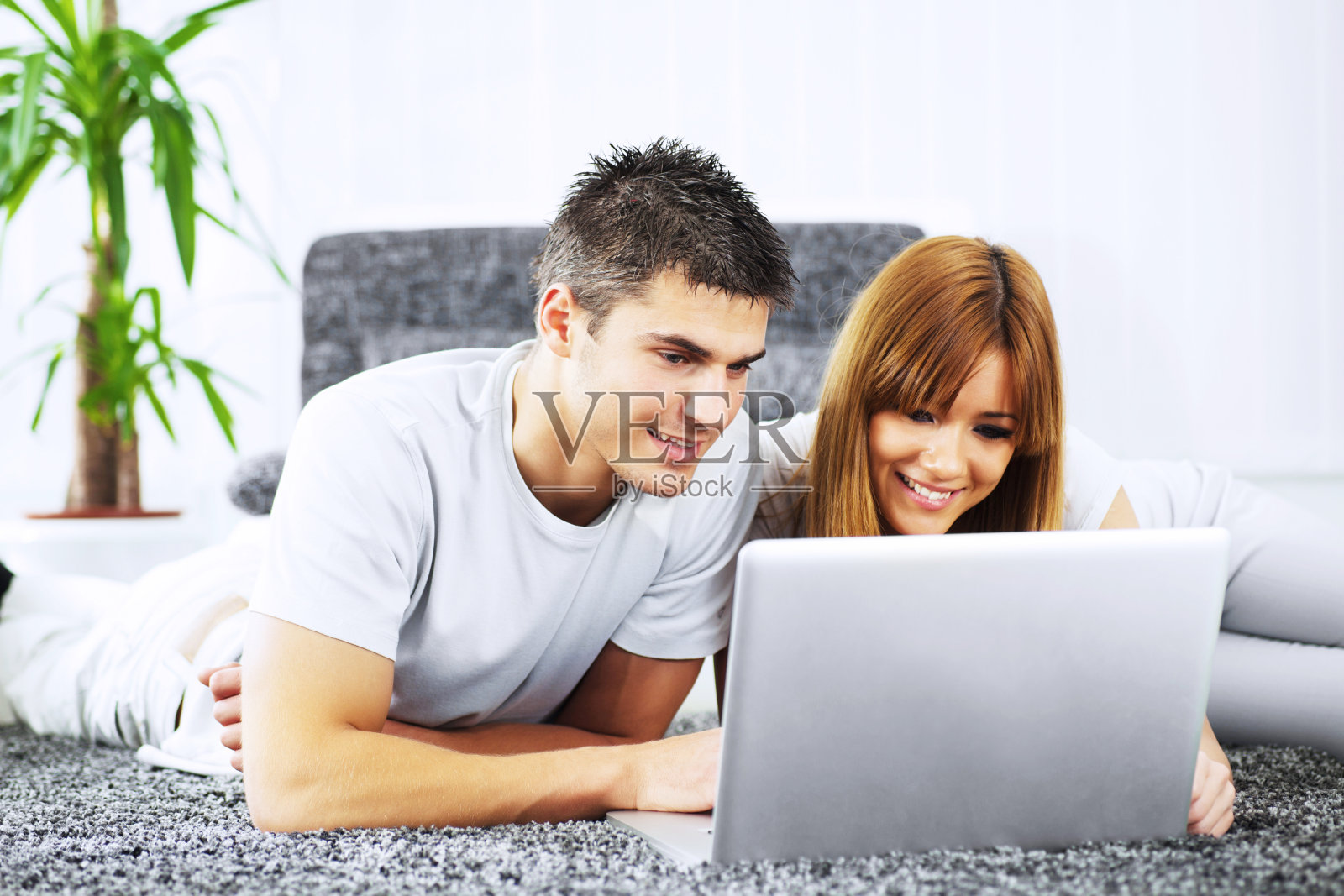 漂亮的年轻夫妇使用笔记本电脑。照片摄影图片