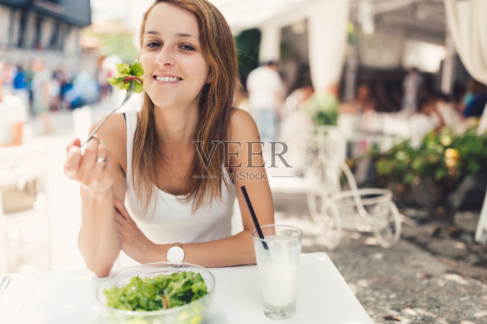 微笑的女人在餐馆吃叶菜照片摄影图片