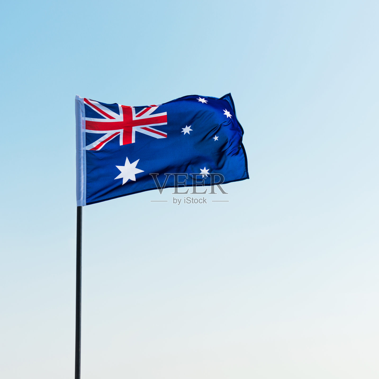 在蓝天下挥舞着澳大利亚国旗照片摄影图片
