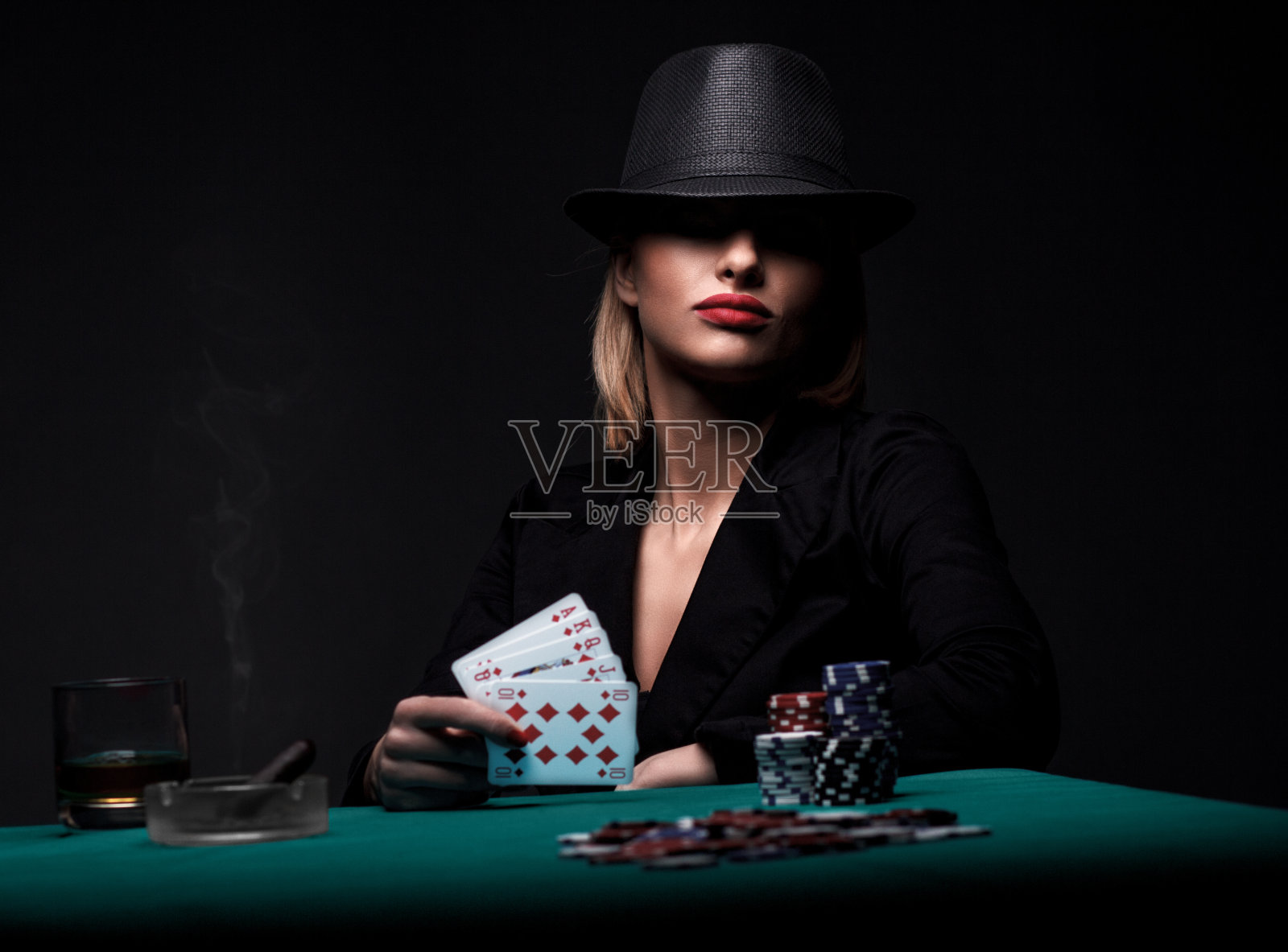 年轻漂亮的女人在玩扑克。照片摄影图片