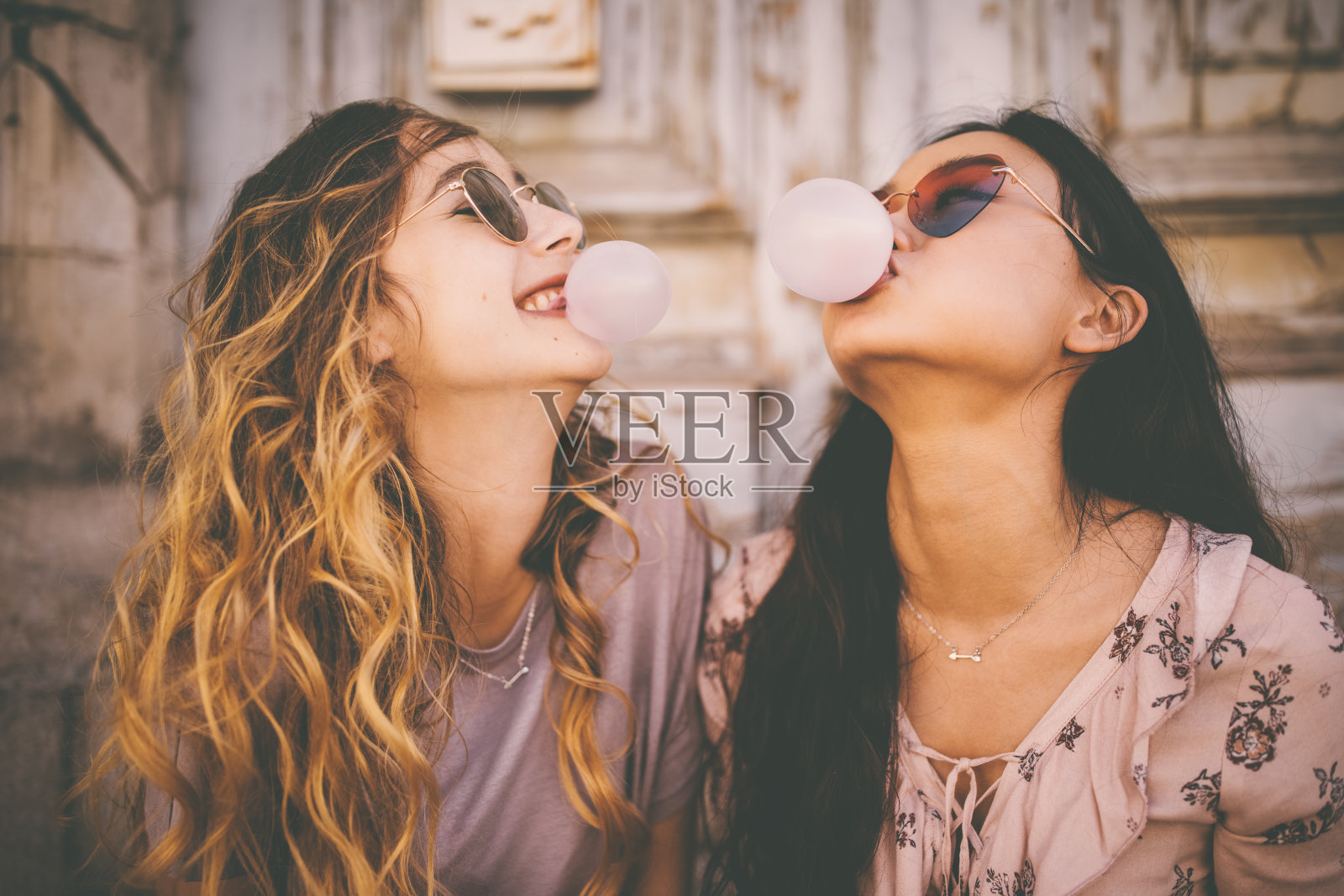 年轻女性在城市里用泡泡糖吹泡泡照片摄影图片