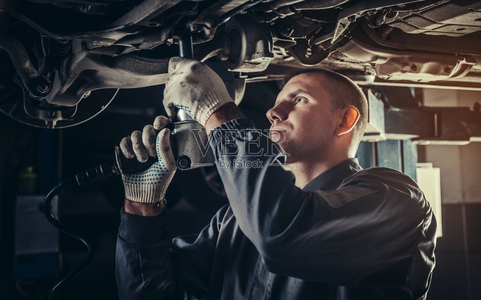 在汽车修理厂修理汽车的专业机械师照片摄影图片