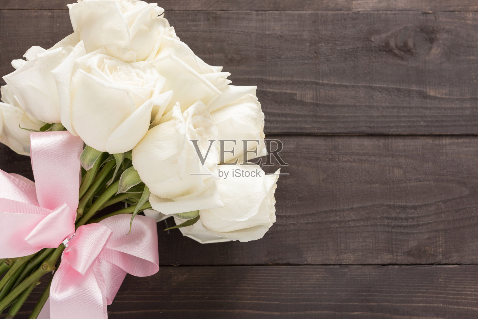 木质背景上是白玫瑰花束和丝带。照片摄影图片