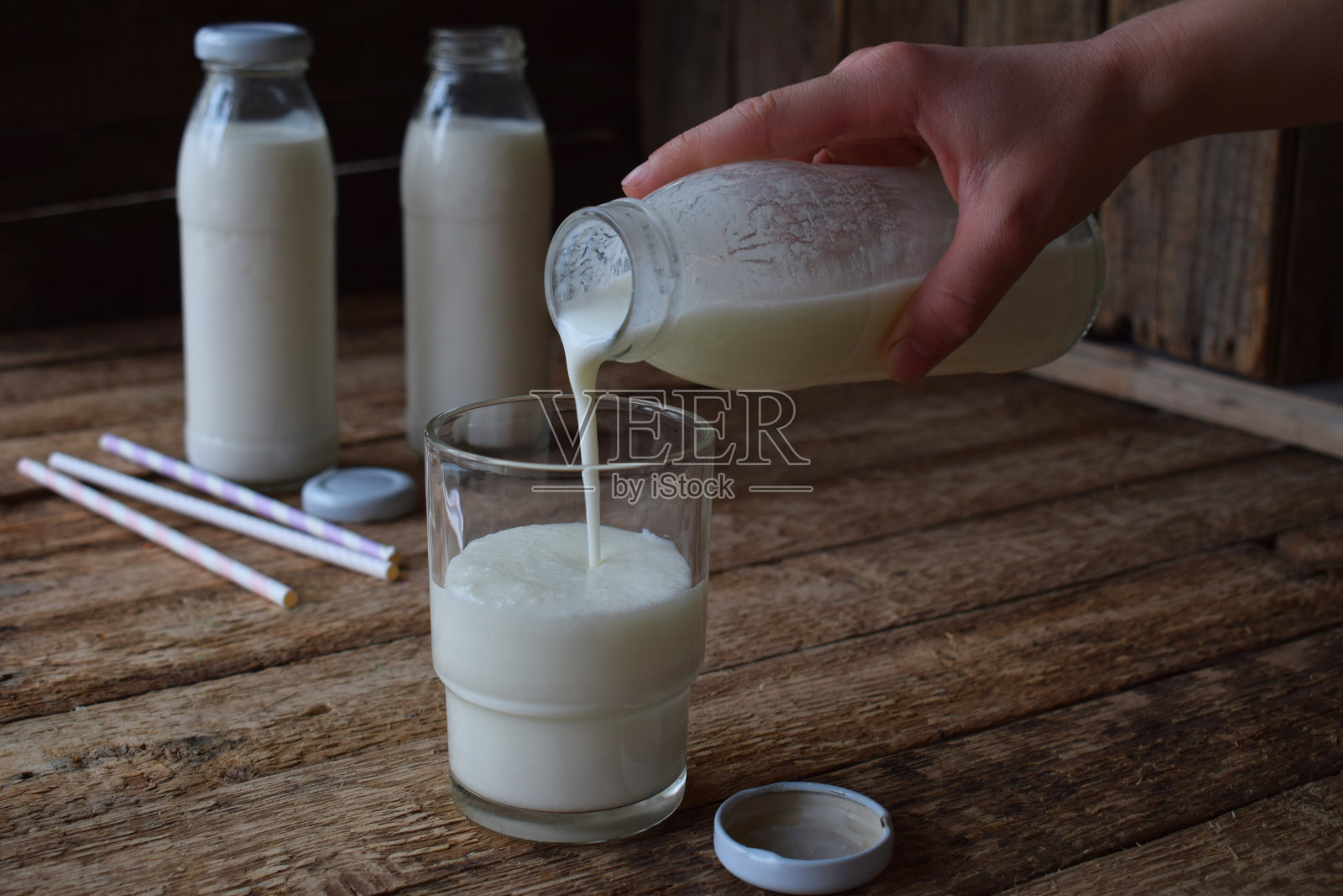 酸乳饮料或酸奶瓶，来自开菲尔谷物和牛奶在木制背景。在自然光下拍摄照片摄影图片
