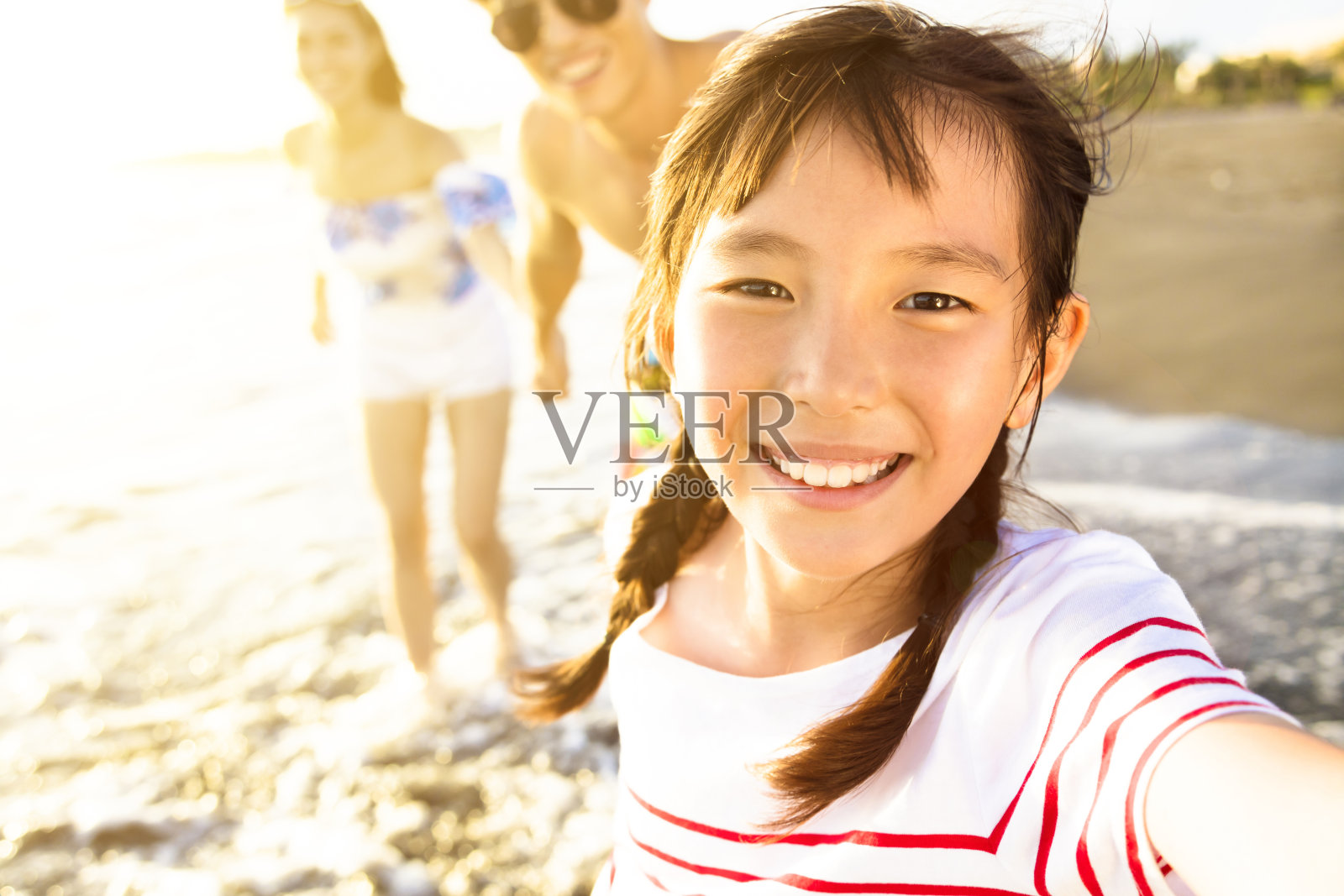 幸福的一家人在海滩上散步享受暑假照片摄影图片