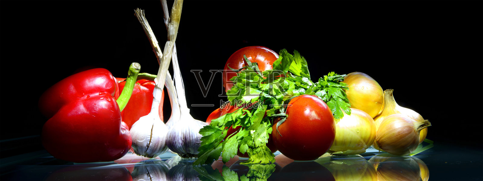 用洋葱，大蒜，胡椒来衬托深色的背景照片摄影图片