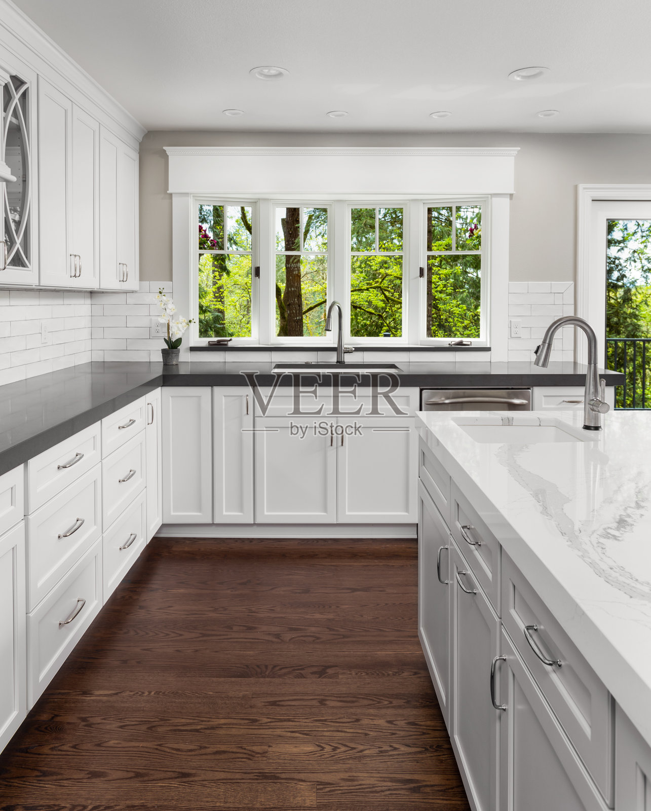 美丽的厨房在新的豪华家庭岛，吊灯，和硬木地板。包括两个水槽。照片摄影图片