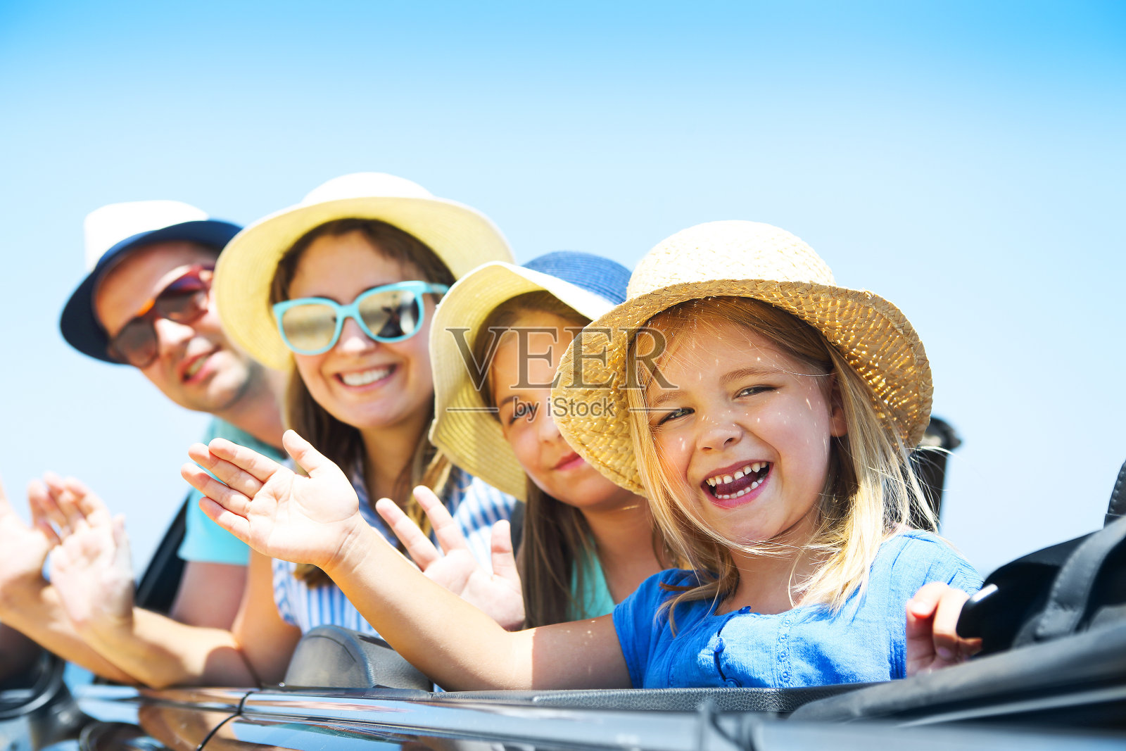 一个微笑的家庭和两个孩子在海滩上的汽车肖像。假日及旅游概念照片摄影图片