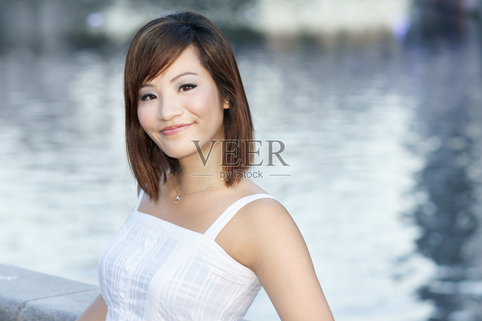 年轻貌美的中国姑娘站在新加坡河边照片摄影图片