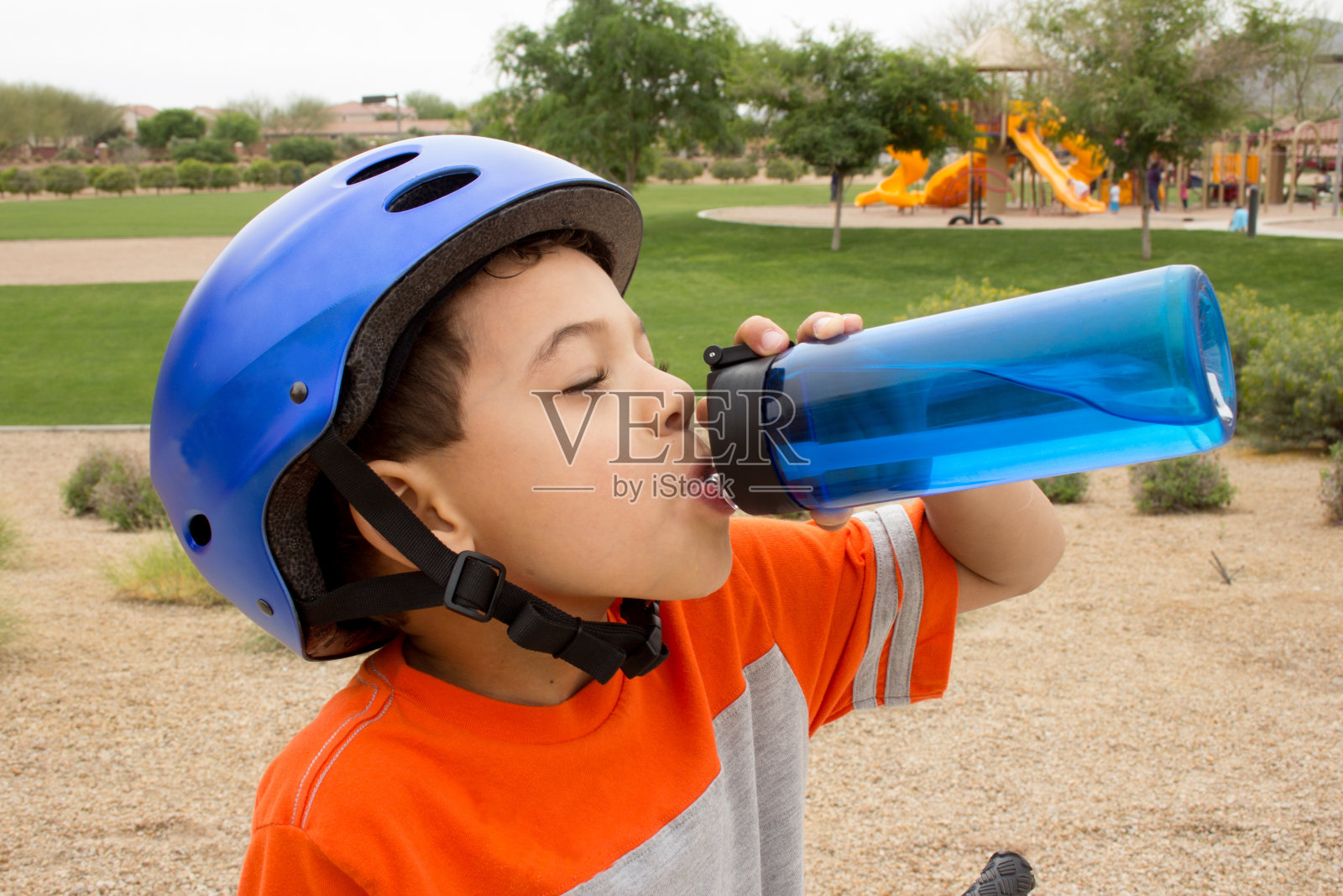 小男孩骑完自行车去补充水分，休息一下照片摄影图片