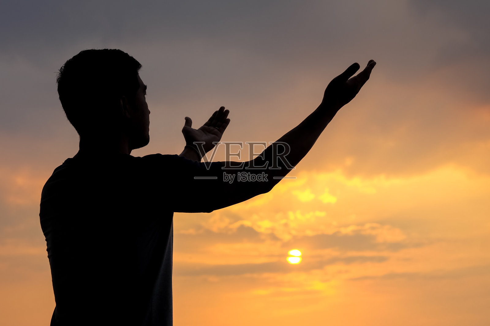 一个人的剪影与手在日落的背景，概念来自天堂的祝福照片摄影图片