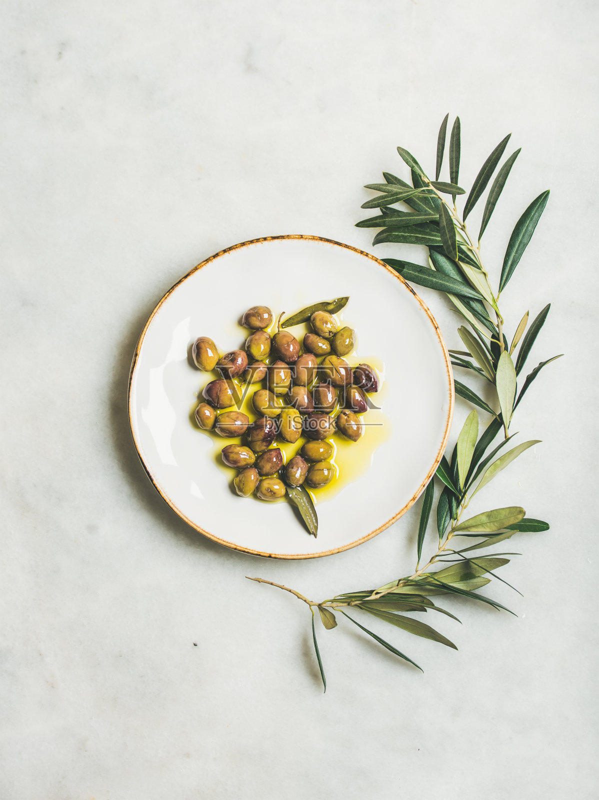 用初榨橄榄油腌制的地中海绿橄榄装盘照片摄影图片