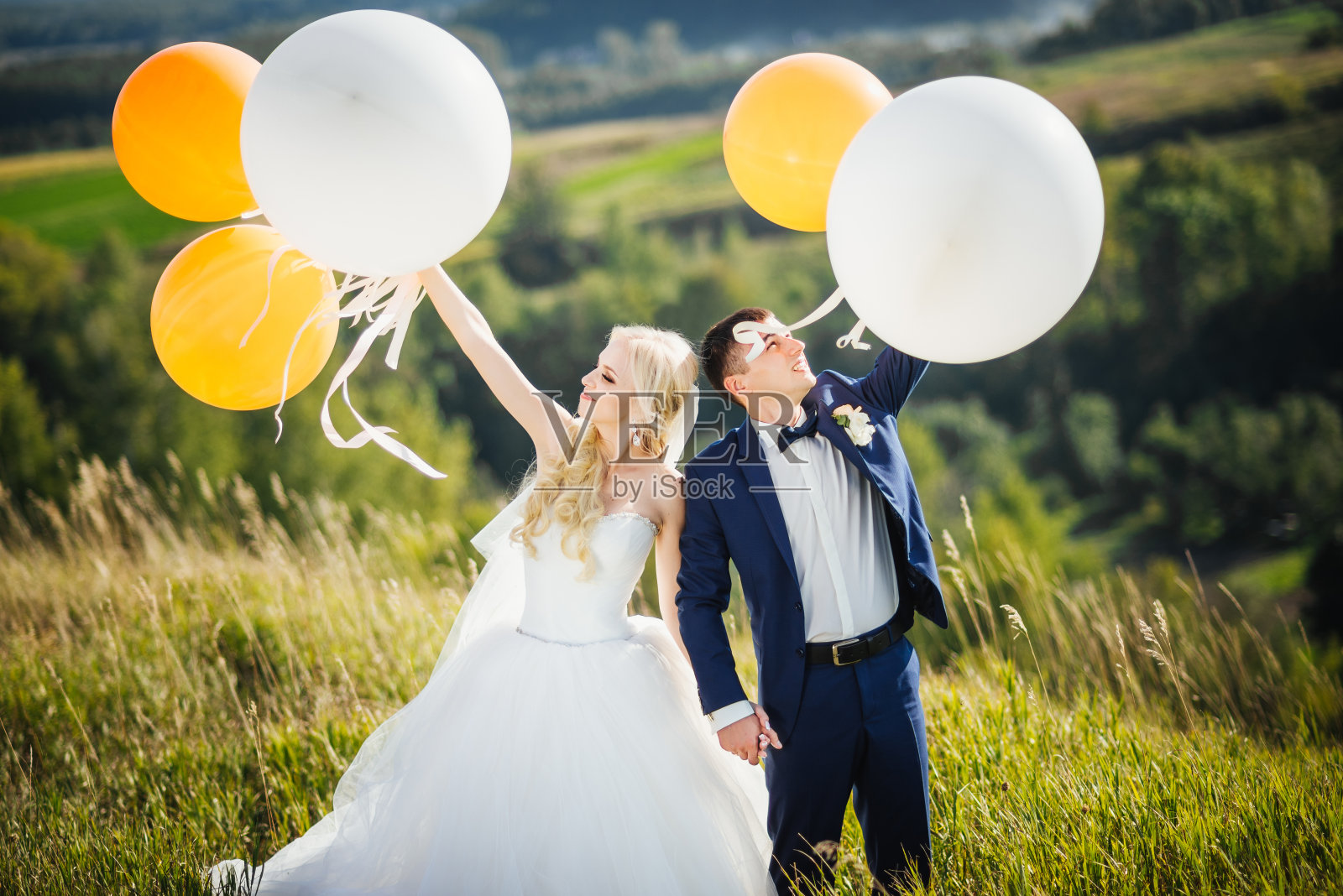 的婚礼。结婚的那一天。喜气洋洋、面带微笑的新婚夫妇在婚礼后拿着氦气球玩。结婚的概念。婚姻照片摄影图片