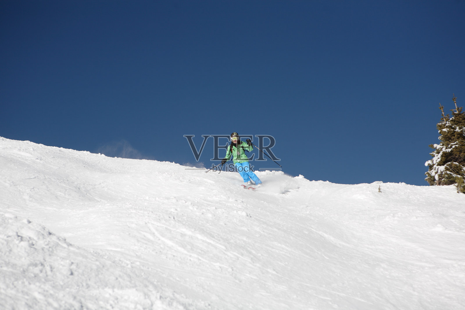 孤独的女子滑雪者在明亮的蓝色天际线上照片摄影图片