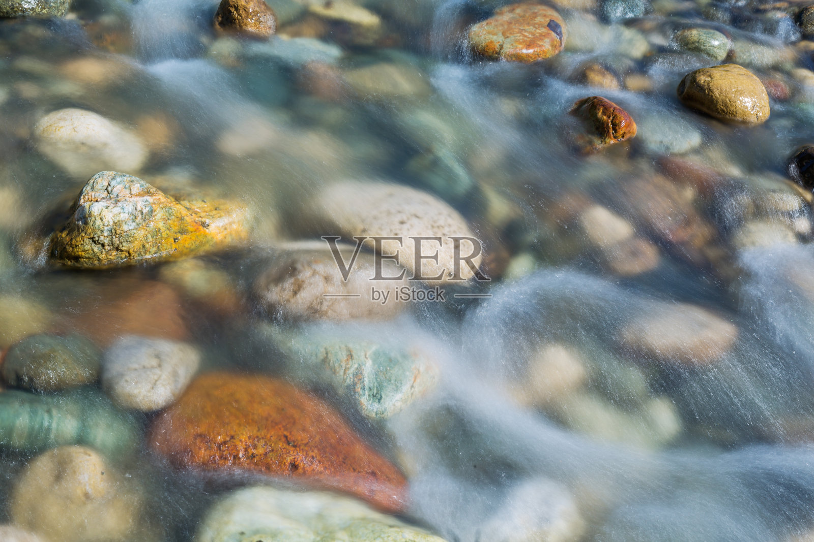 卵石石在河水中近观，照片摄影图片